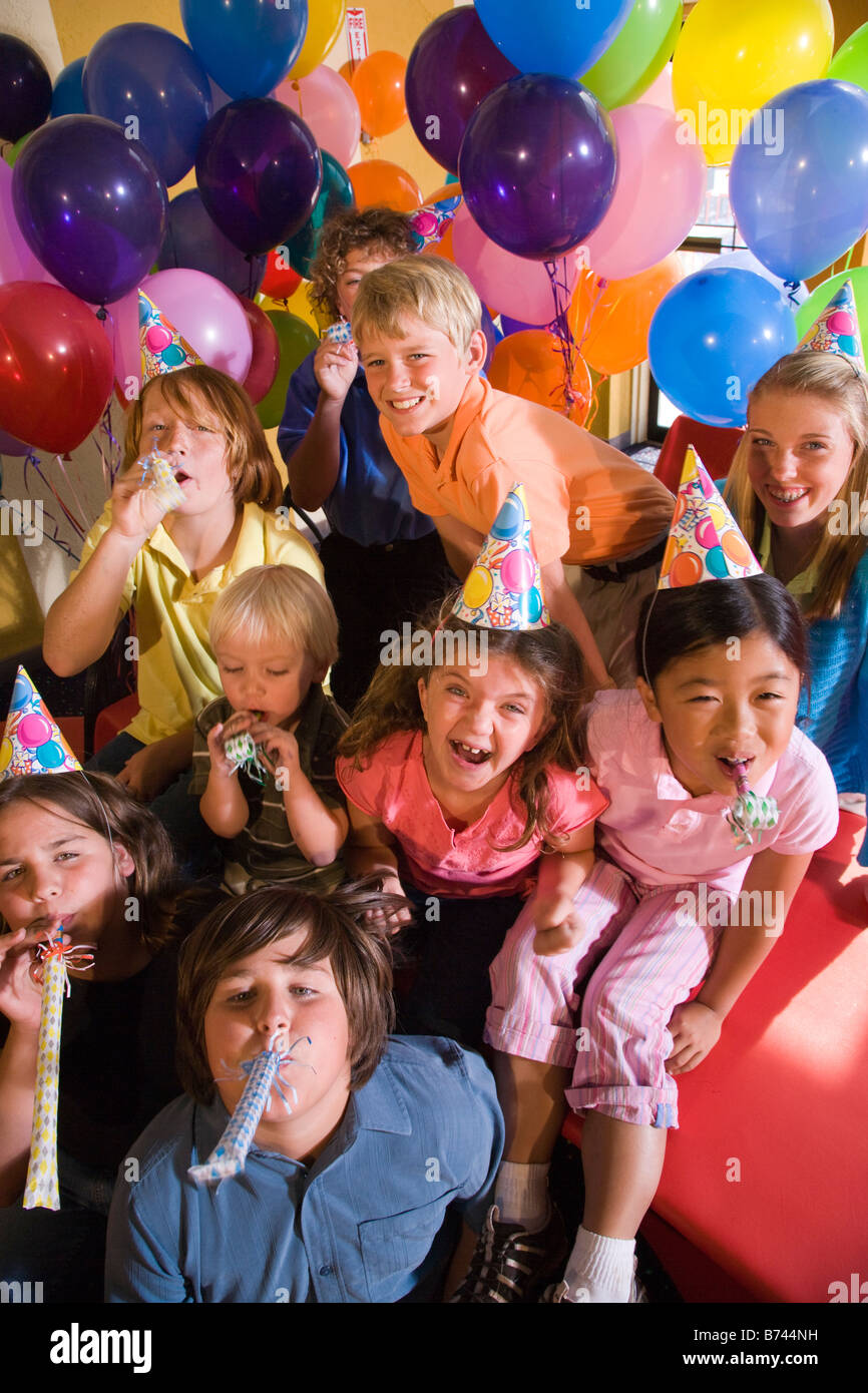 Kinder weht Hörner auf Geburtstagsparty Stockfoto
