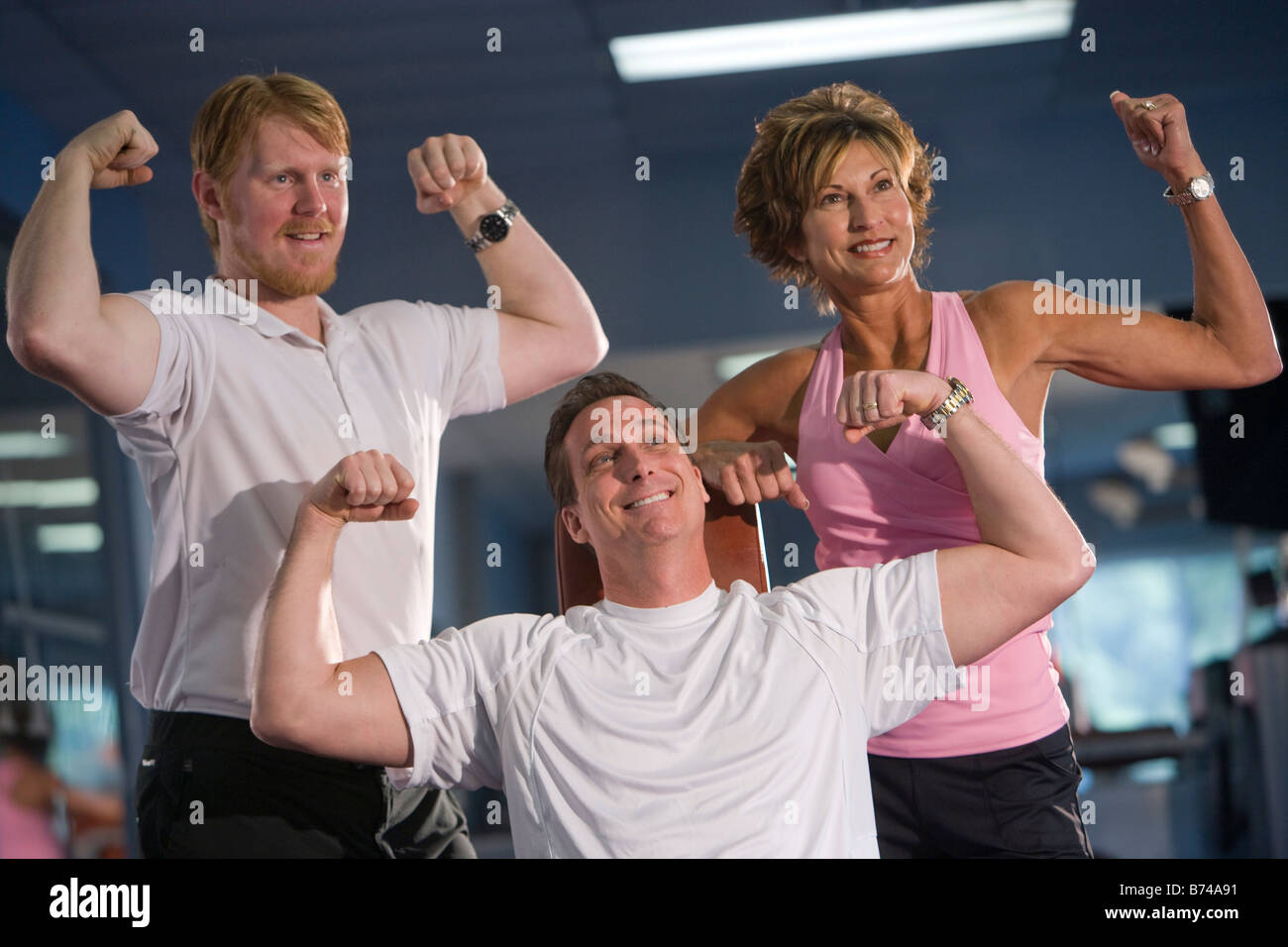 Paar mittleren Alters mit personal Trainer im Fitness-Studio Stockfoto