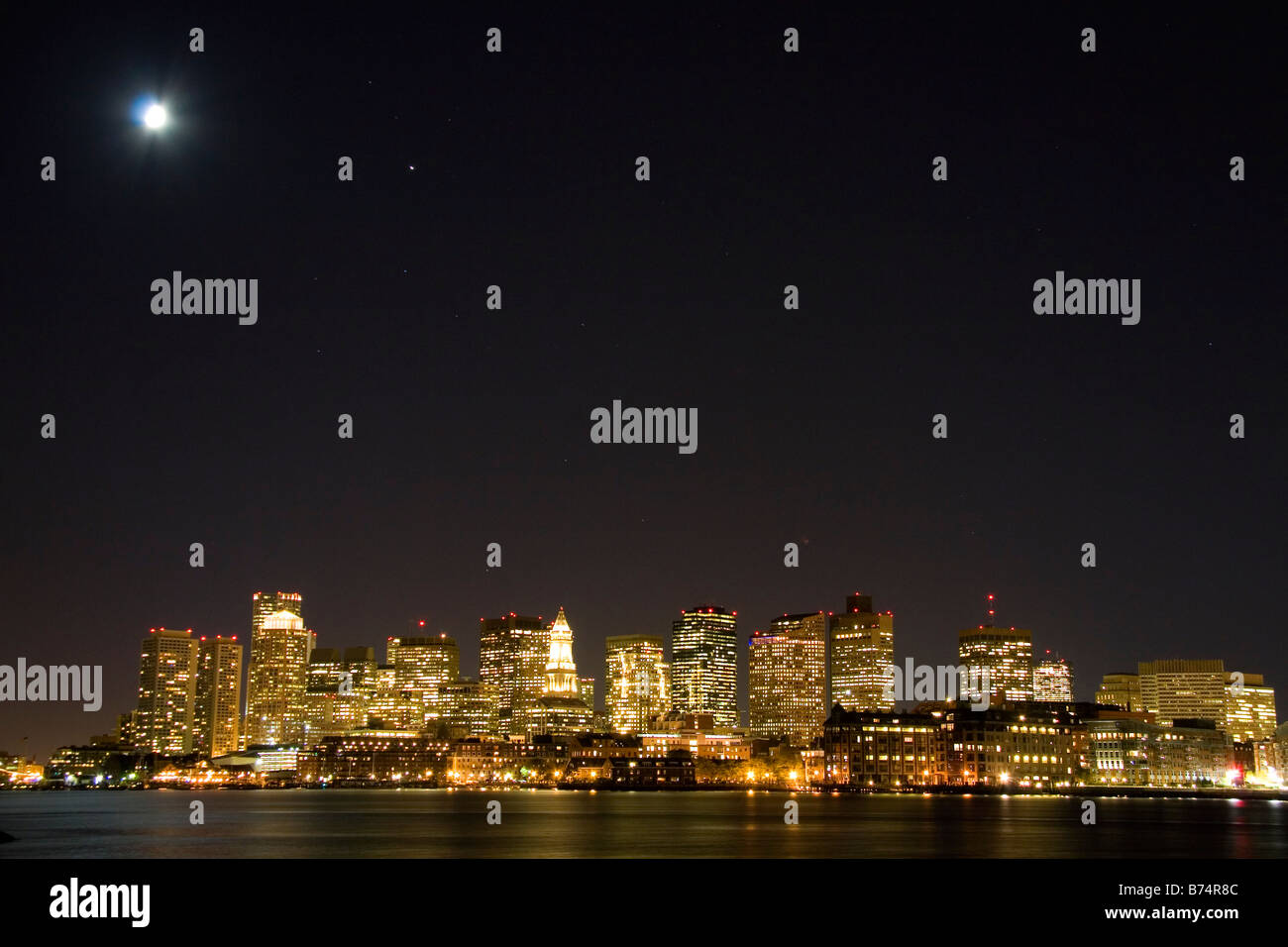 Skyline von Boston in einer sternenklaren Nacht Mondlicht mit Boston Harbor im Vordergrund Massachusetts, USA Stockfoto