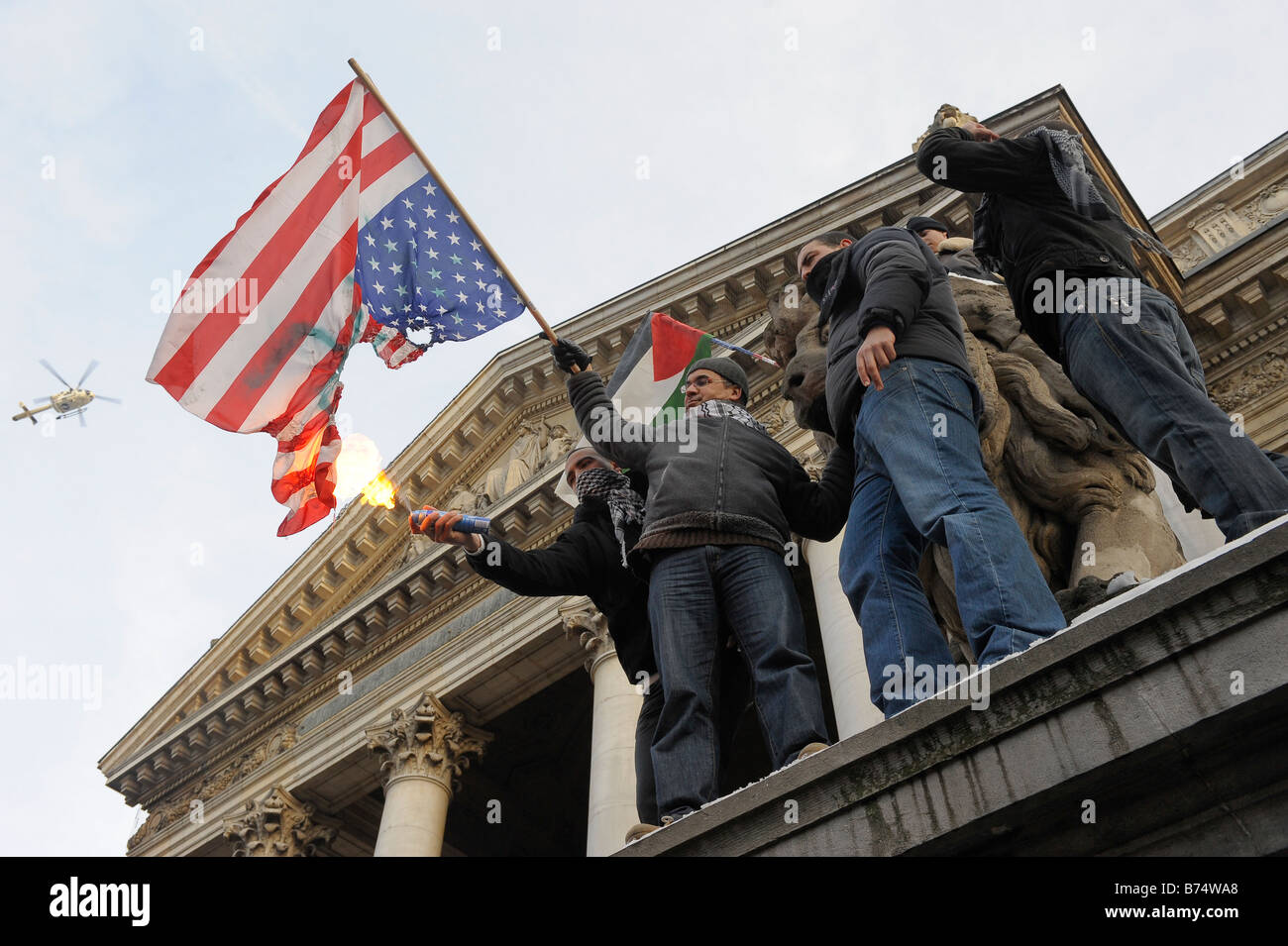 Manifestators US-Flagge zu verbrennen, während der Demonstration gegen die anhaltende Gewalt im Gazastreifen in Brüssel, Belgien Stockfoto