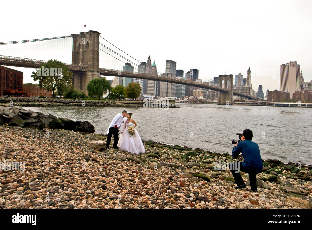 Hochzeit paar von Brooklyn Bridge in New York mit Manhattan Skyline im Hintergrund fotografiert Stockfoto