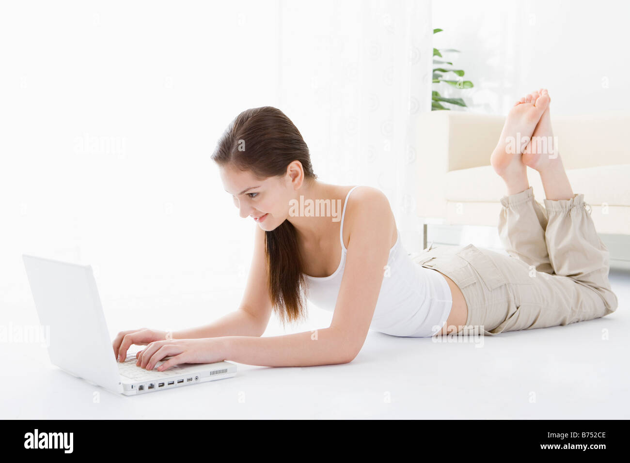 Teenager-Mädchen auf Boden mit laptop Stockfoto