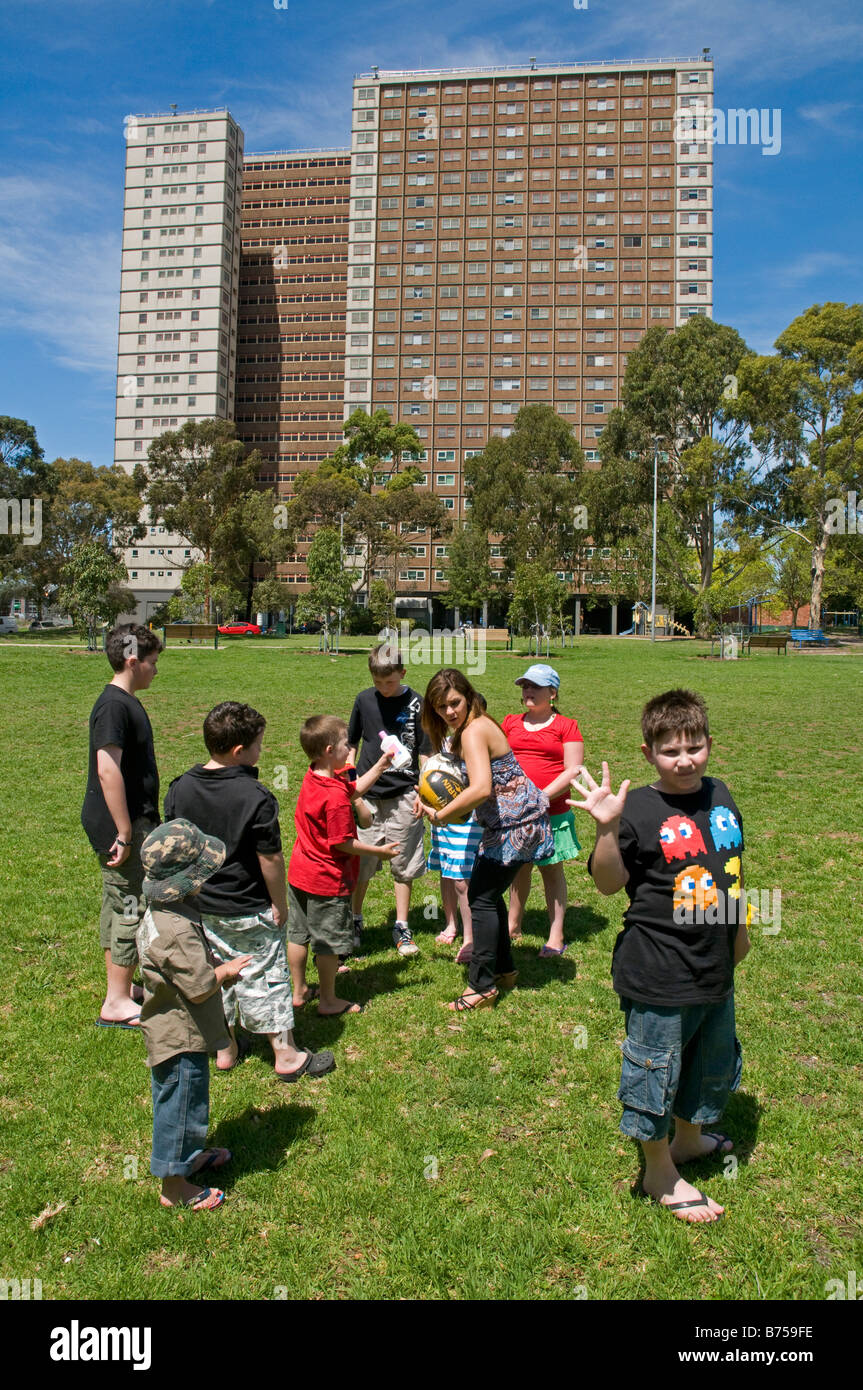 Kinder spielen in einem Park in der Nähe von einem großen innerstädtischen Block Gehäuse Kommission Apartments in Richmond Melbourne Australien Stockfoto