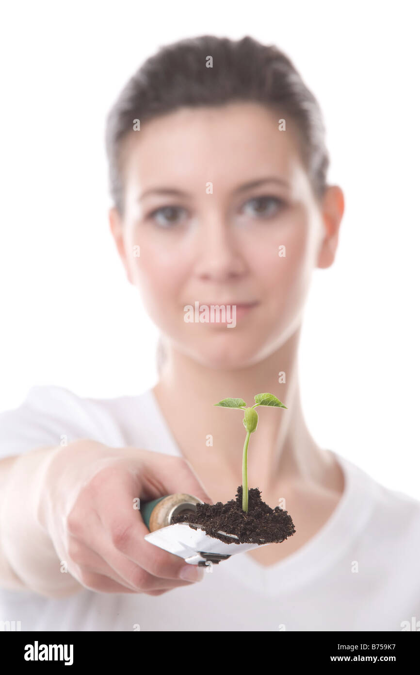 Gesicht einer jungen Frau mit einer Kelle und kleine Pflanze, Winnipeg, Manitoba Stockfoto