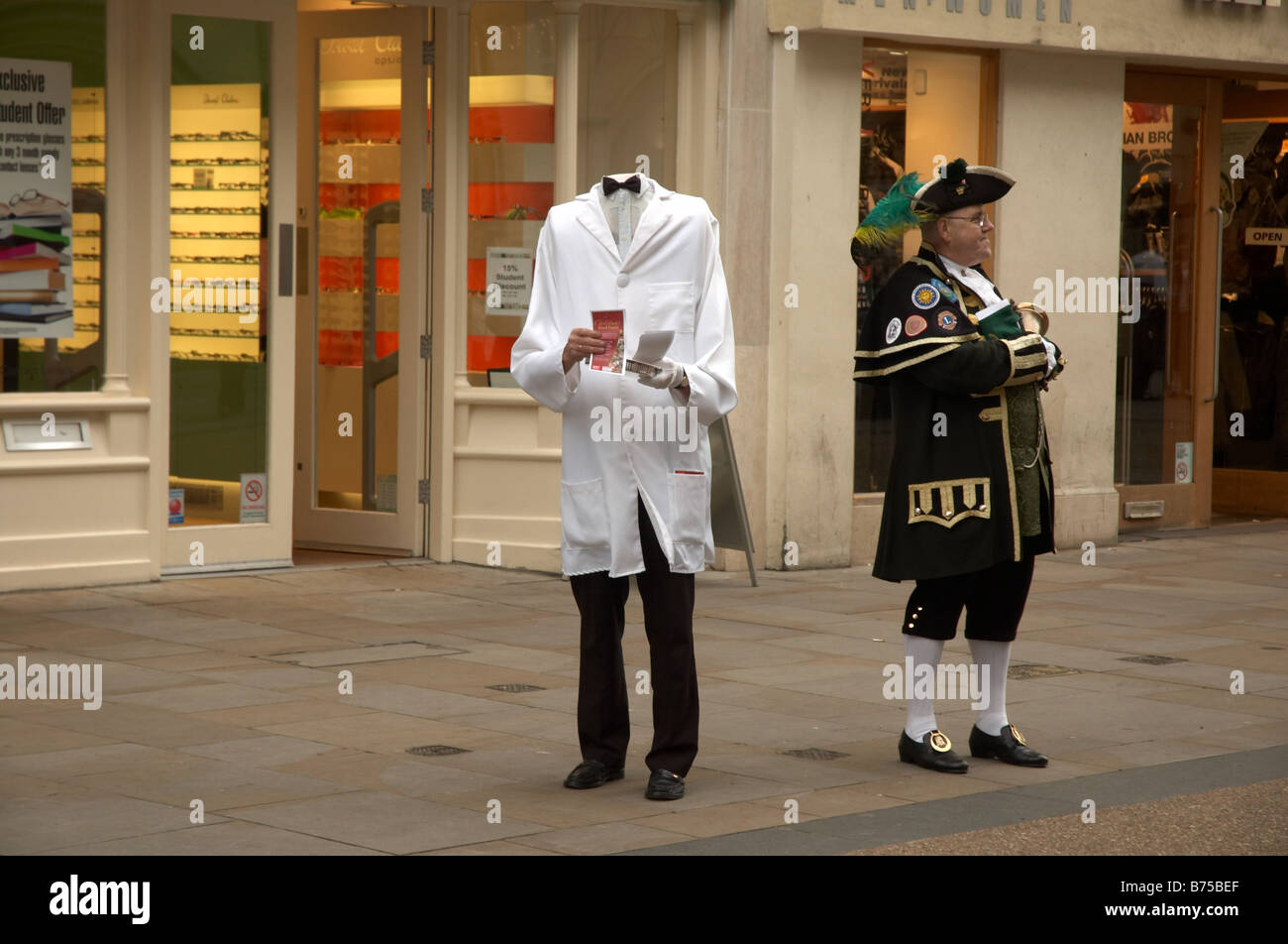 Eine Person in einem kopflosen Mann Kostüm verteilen Flugblätter in der Cornmarket Street in Oxford an der Seite ein Ausrufer Stockfoto