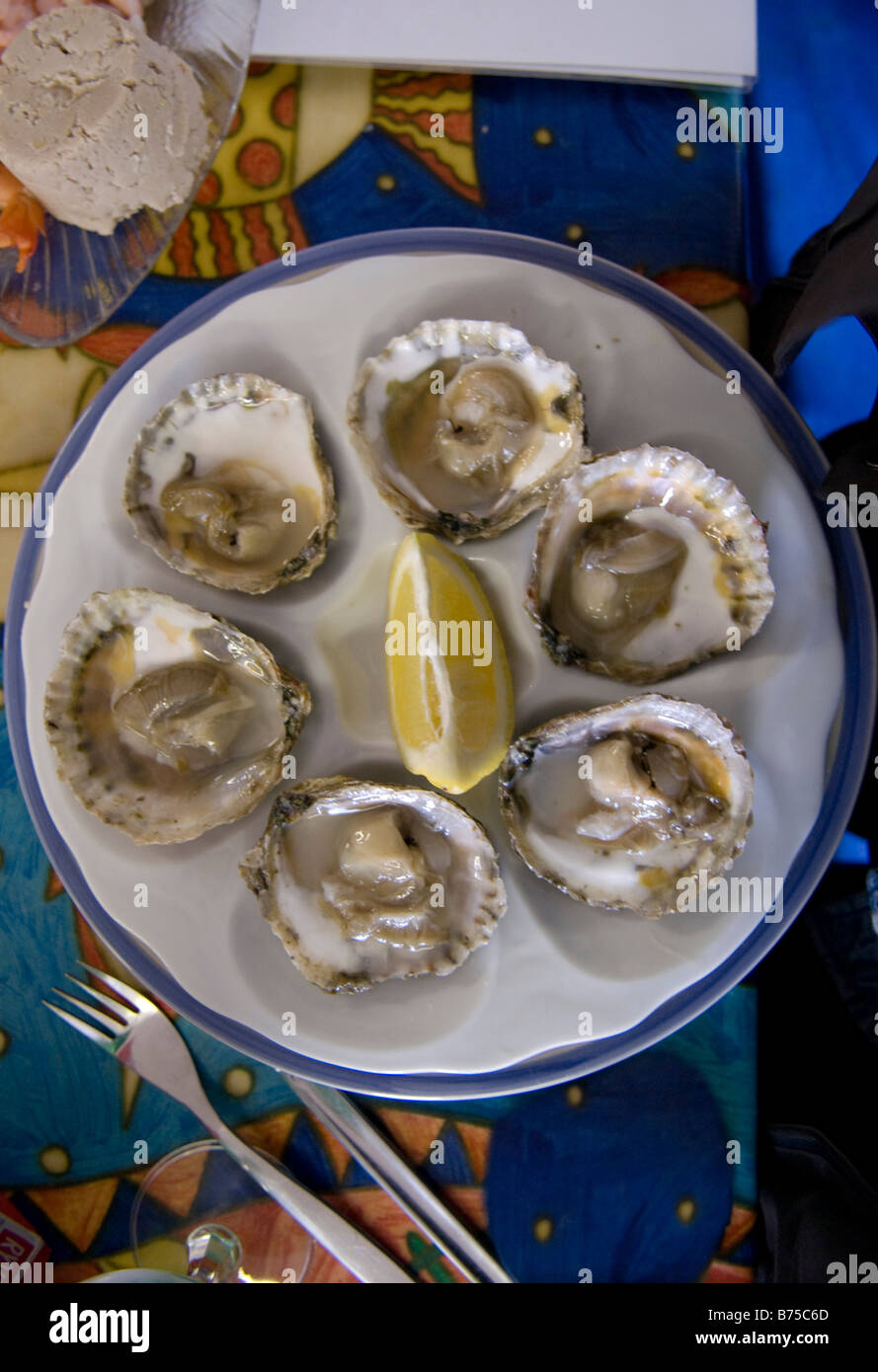 Austern und Zitrone auf Platte Mersea Essex English UK am Meer Fisch und Meeresfrüchte Stockfoto