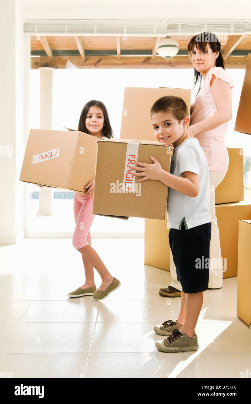 Seitenansicht einer Familie tragen Kartons Stockfoto