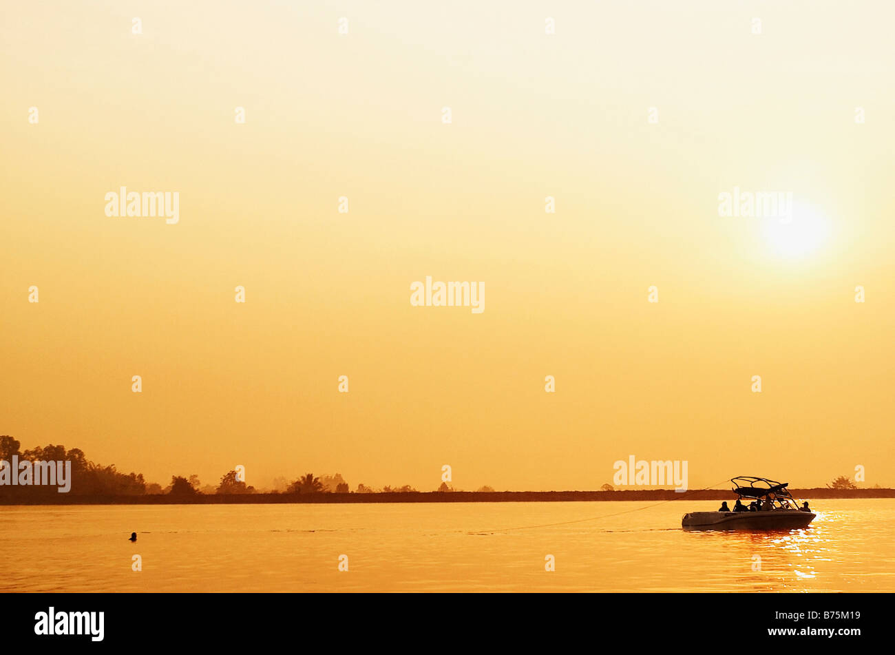 Gruppe von Personen in einem Boot bei Sonnenuntergang, Amphoe Mueang, Chiang Rai, Provinz Chiang Rai, Thailand Stockfoto