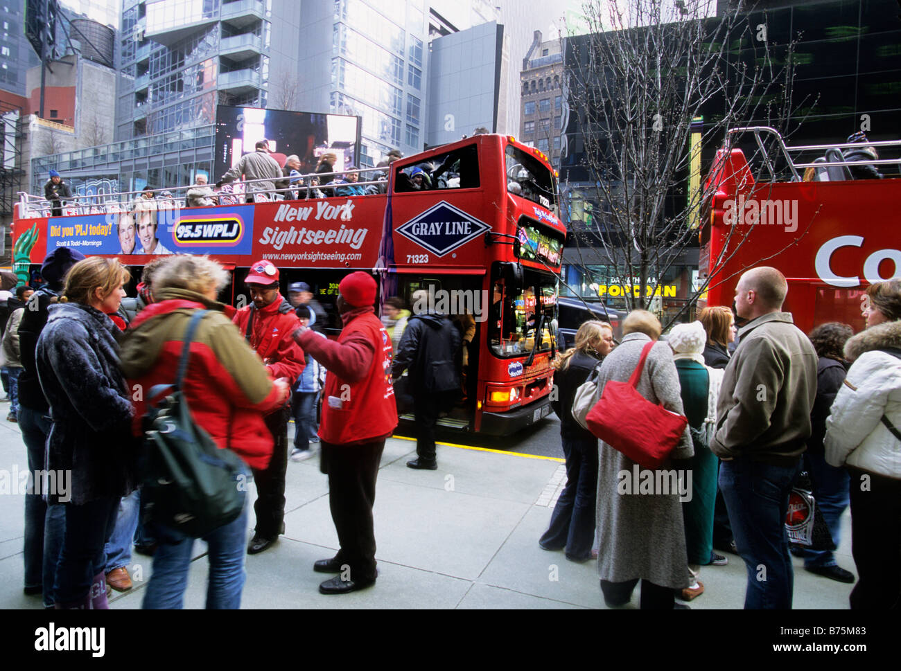 Times Square Broadway New York City. Touristen, die in Midtown Manhattan, USA, an Bord eines offenen Gray Line Sightseeing-Busses warten Stockfoto