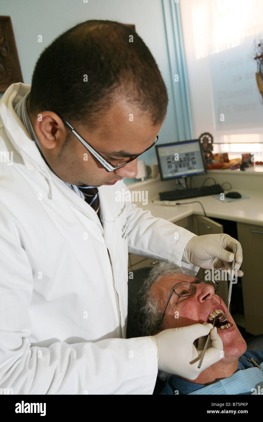 ein Zahnarzt Zahnarztpraxis bei einem männlichen Patienten mit Hypnose und nicht mit Betäubung durchführen Stockfoto