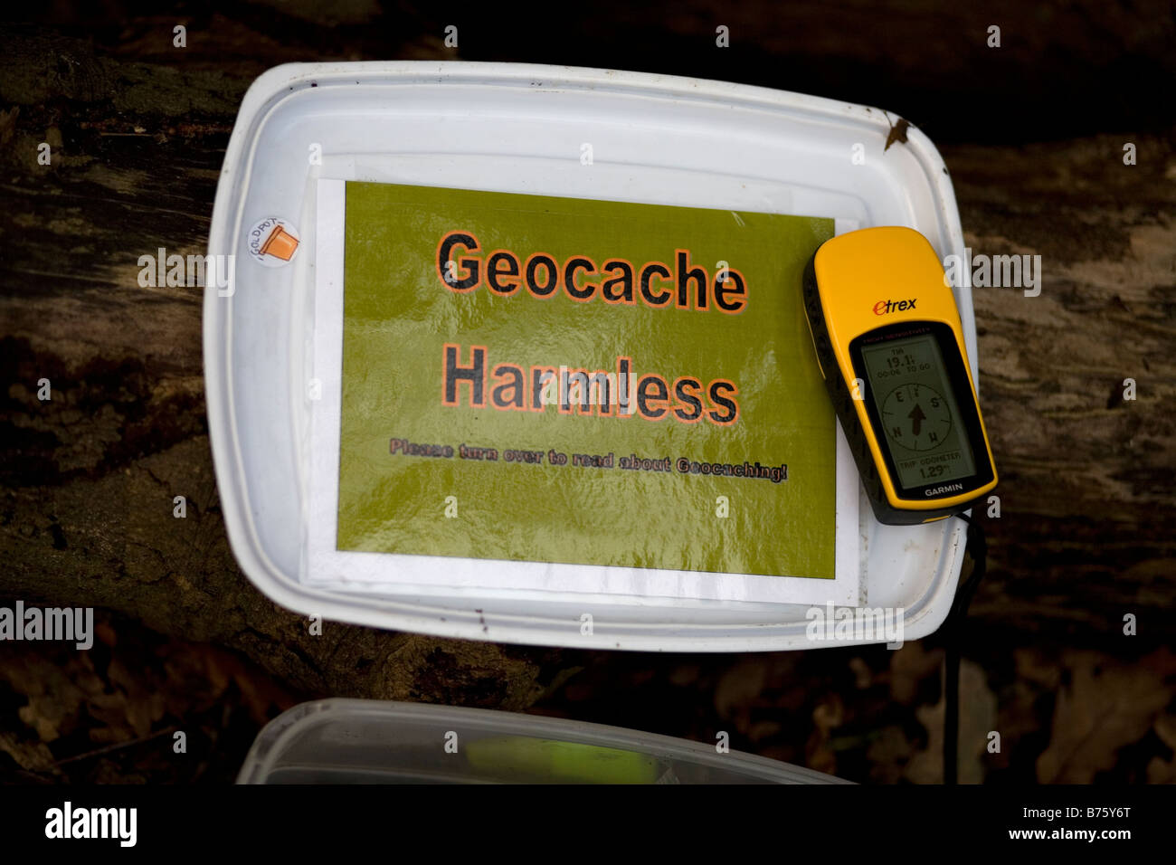 Die Innenseite des Deckels einen Geocache-Schatzkiste gefunden in der Landschaft mit einem GPS-Gerät an der Spitze Stockfoto