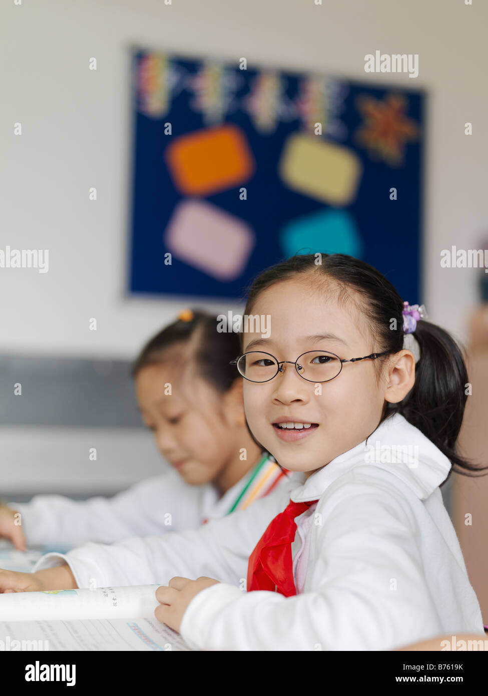 Ein Klassenzimmer von jungen chinesischen Studenten, die eine Lektion aus ihrem Lehrbuch zu lesen. Stockfoto