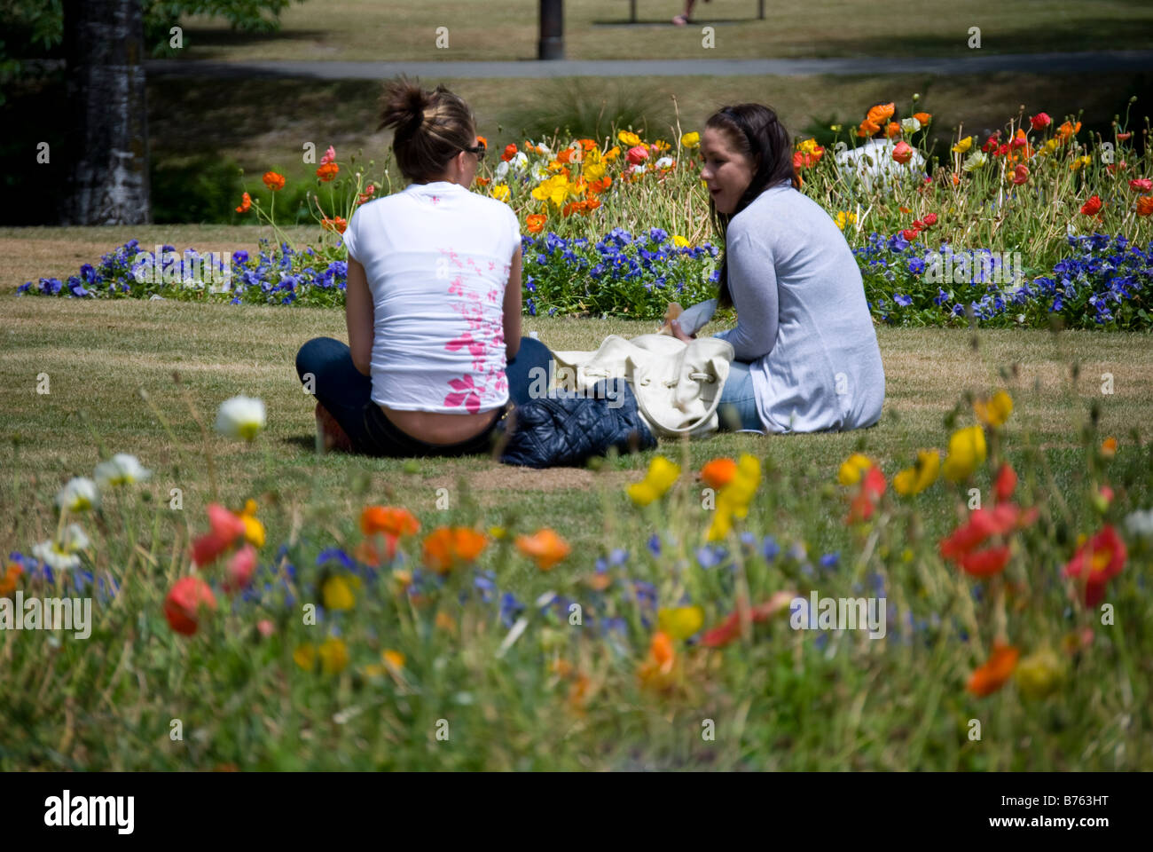 Junge Frauen mit Mittagessen am Ufer des Flusses Avon, Oxford Terrasse, Christchurch, Canterbury, Neuseeland Stockfoto