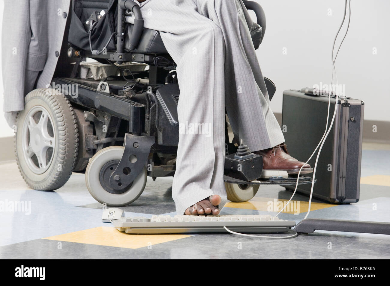 Geschäftsmann mit zerebraler Lähmung arbeiten auf einem Computer mit seinem Fuß Stockfoto