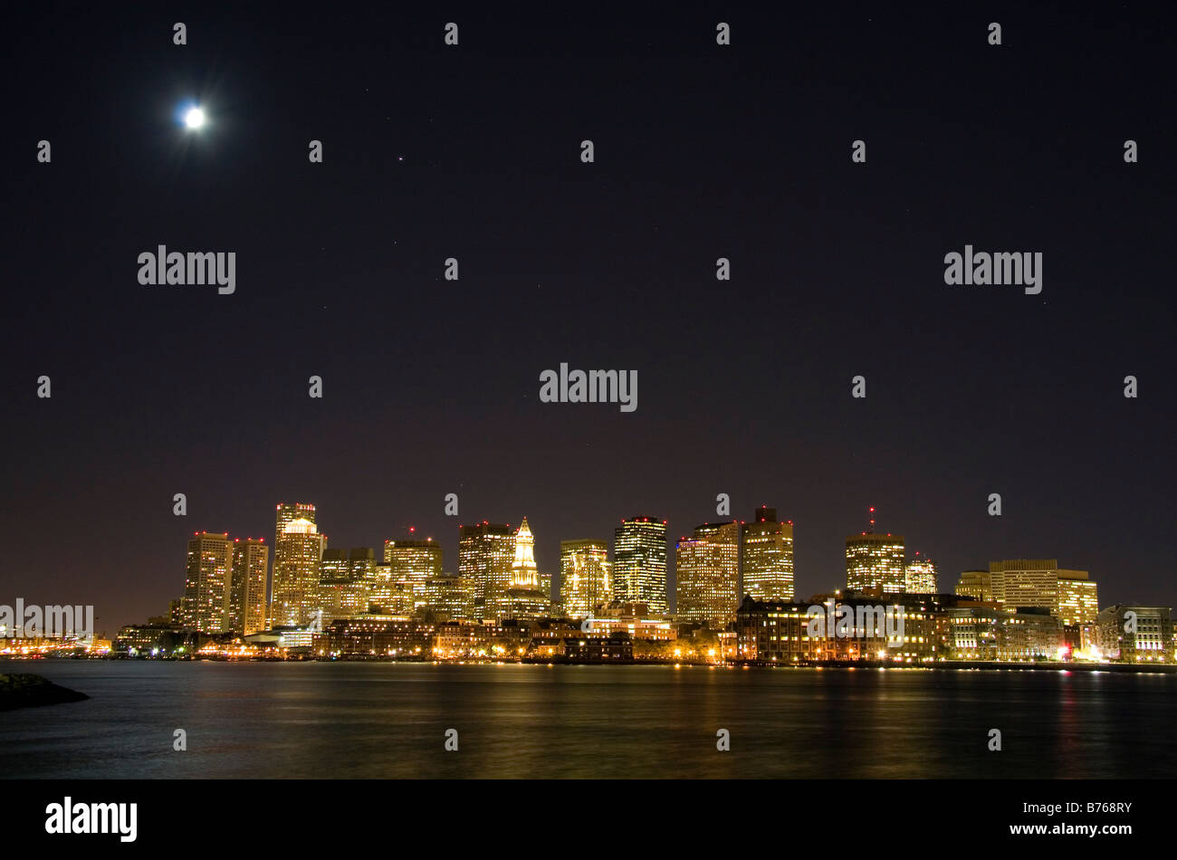 Skyline von Boston in einer sternenklaren Nacht Mondlicht mit Boston Harbor im Vordergrund Massachusetts, USA Stockfoto