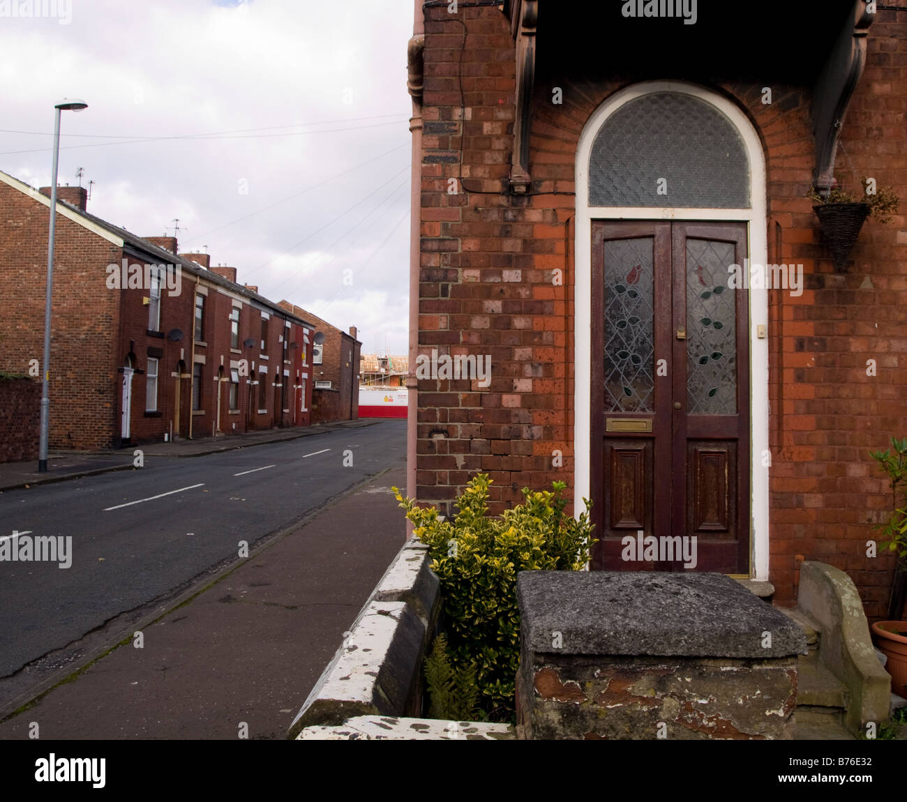 Traditionelles britisches Englisch-Haus in der Nähe mit Brettern vernagelt verlassenen Straße in Manchester Stockfoto