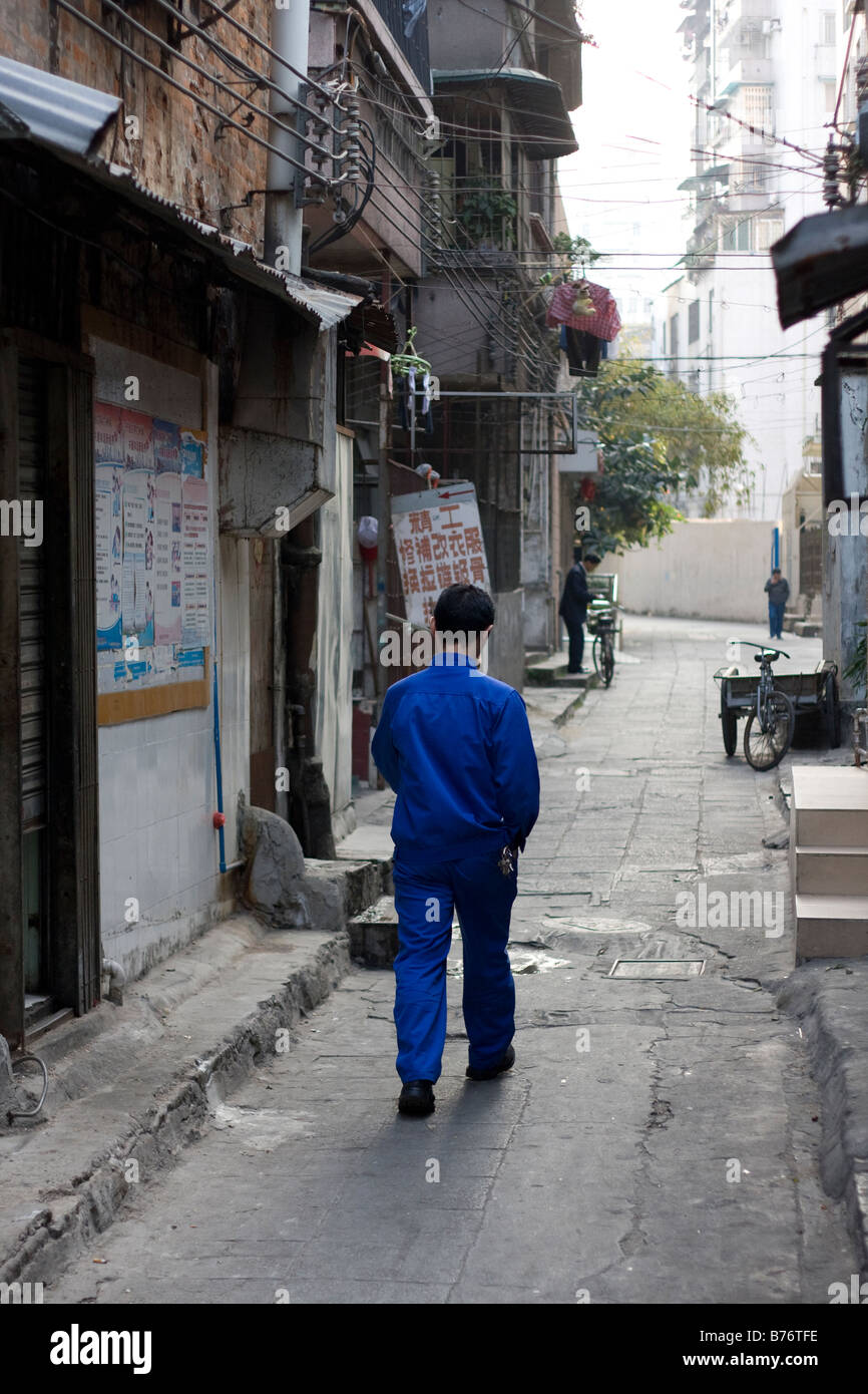 Mann allein zu Fuß morgens nach unten Gasse Seitenstraße in Guangzhou China chinesische Zeichen Stockfoto