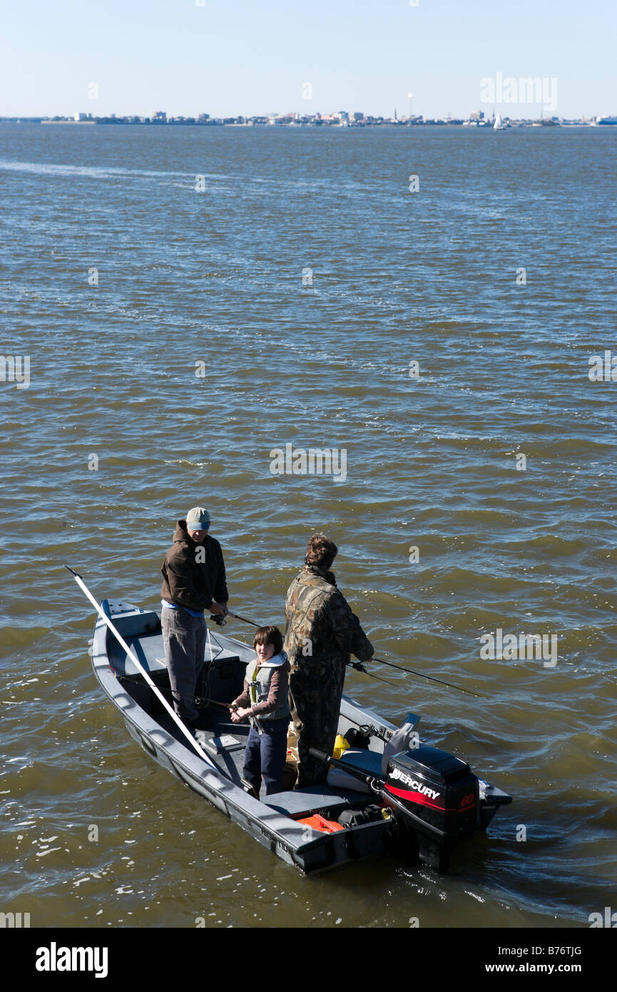 Zwei Männer und eine junge Fischerei vor Fort Sumter im Hafen von Charleston mit der Stadt Charleston hinter, South Carolina Stockfoto