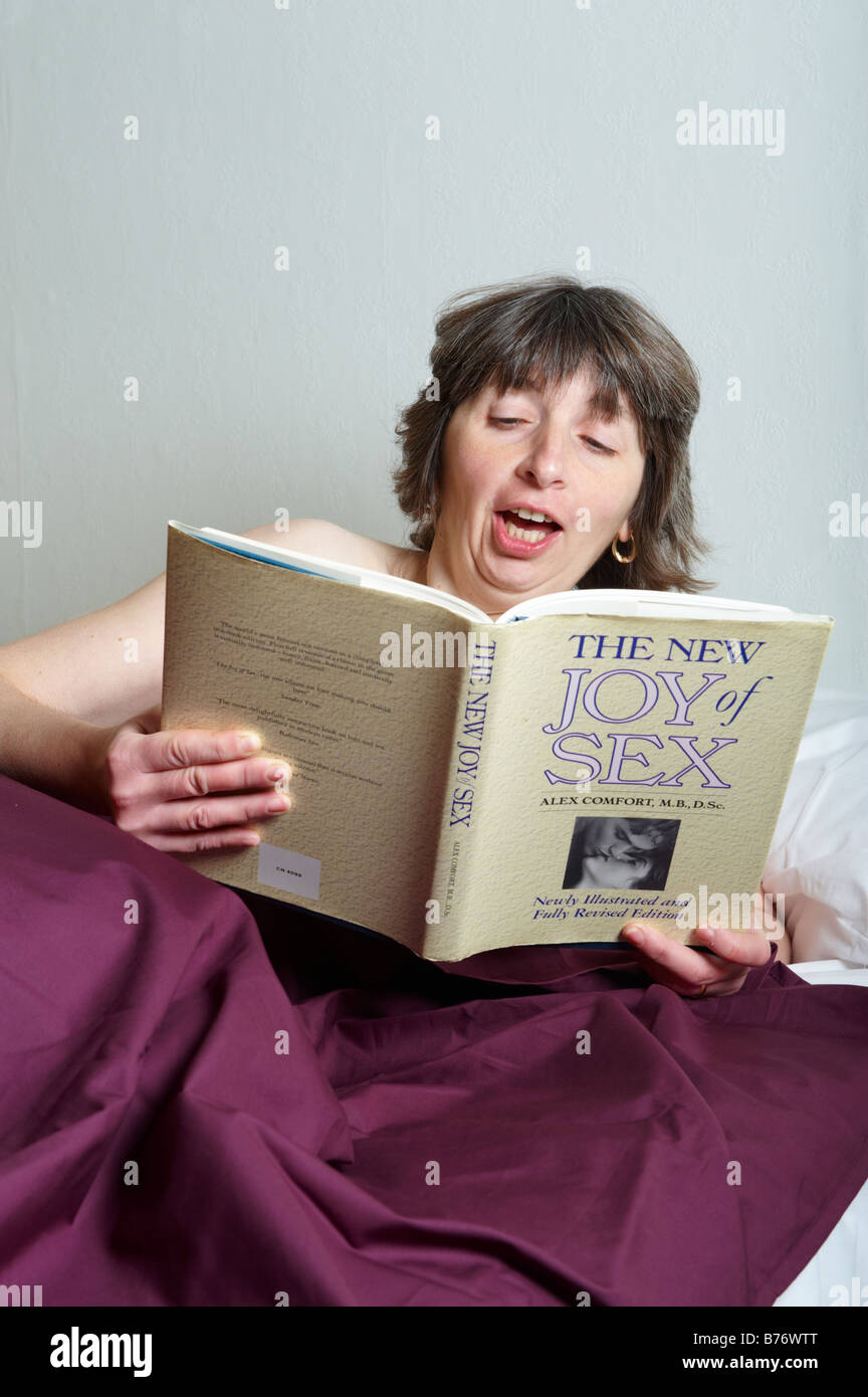 Applying Frau im Bett und las ein Buch über sex Stockfoto