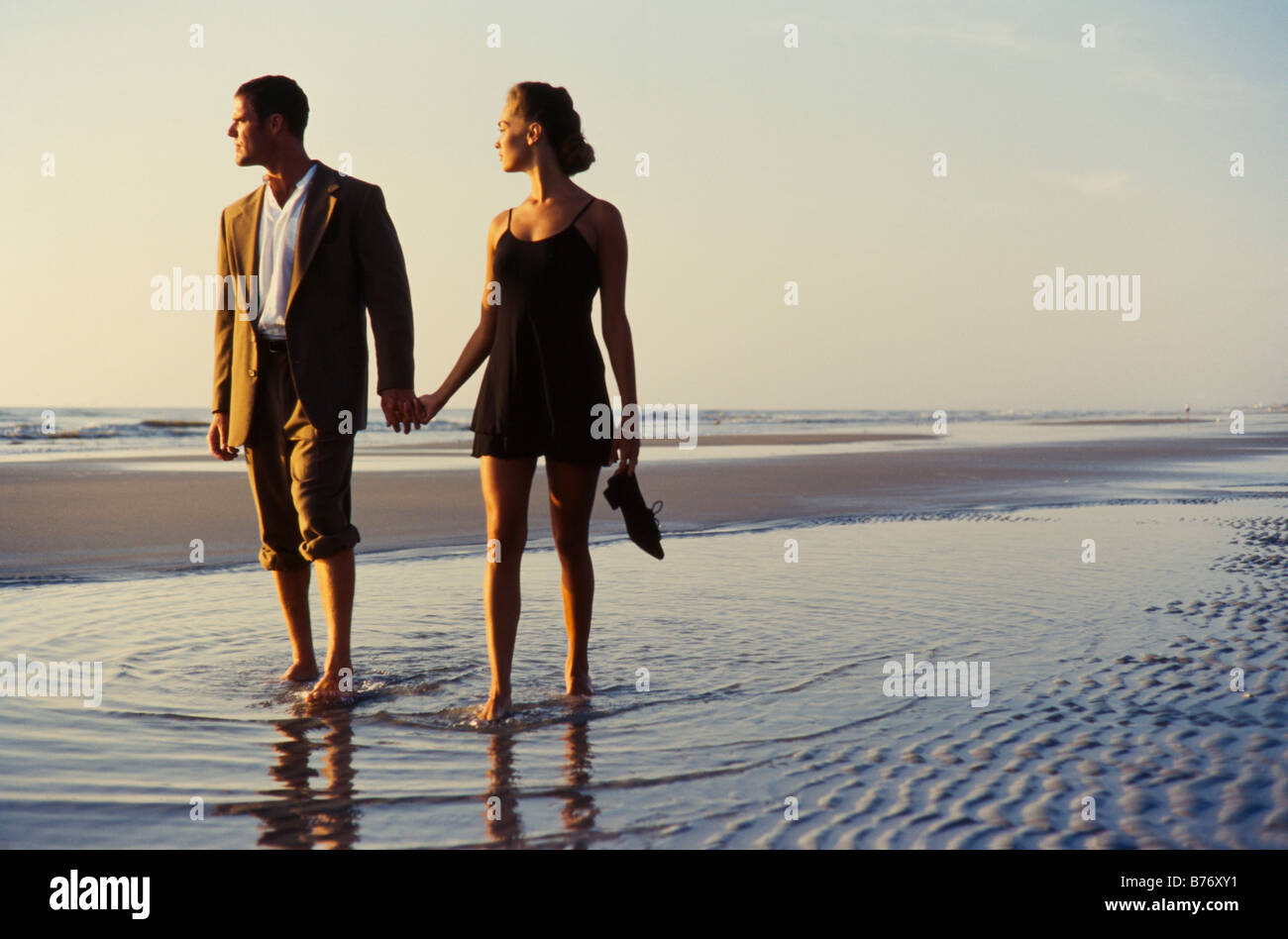 Junges Paar zu Fuß am Strand, elegant gekleidet, Miami Stockfoto