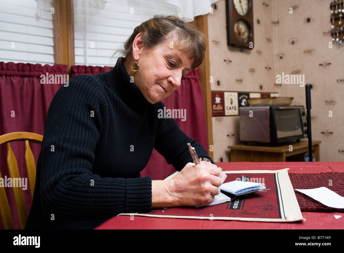 Eine Frau, die einen Scheck, monatlichen Rechnungen zu bezahlen. Stockfoto