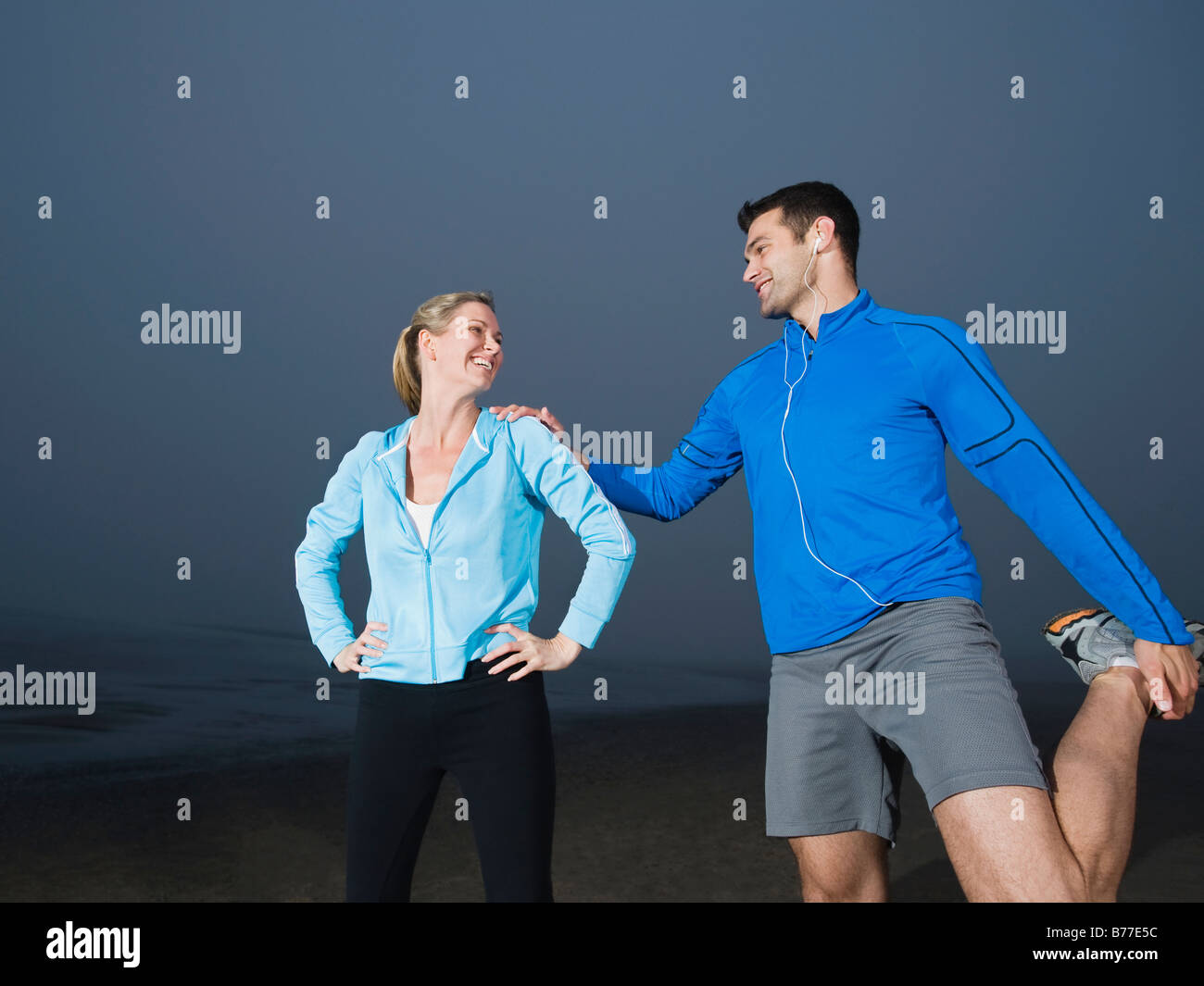 Paar am Strand dehnen Stockfoto