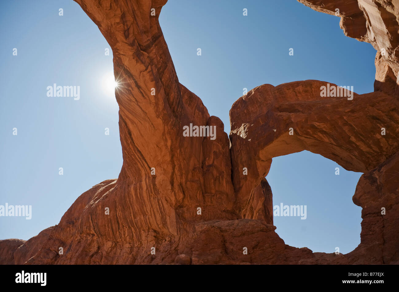 Sonne hinter Double Arch Arches National Park, Utah Stockfoto