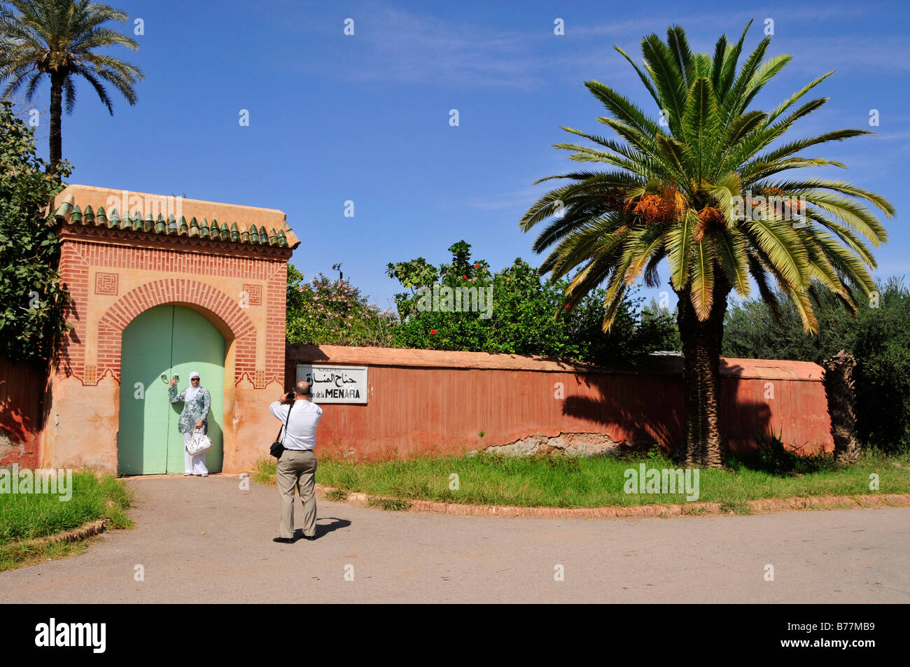 Marokkanische paar Fotografieren am Eingang der Saadier-Palais am Menara-Gärten, Marrakesch, Marokko, Afrika Stockfoto