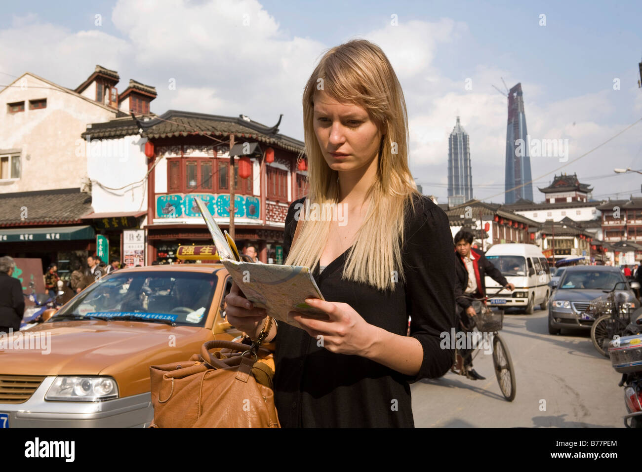 Junge Frau liest eine Karte, Shanghai, China, Asien Stockfoto