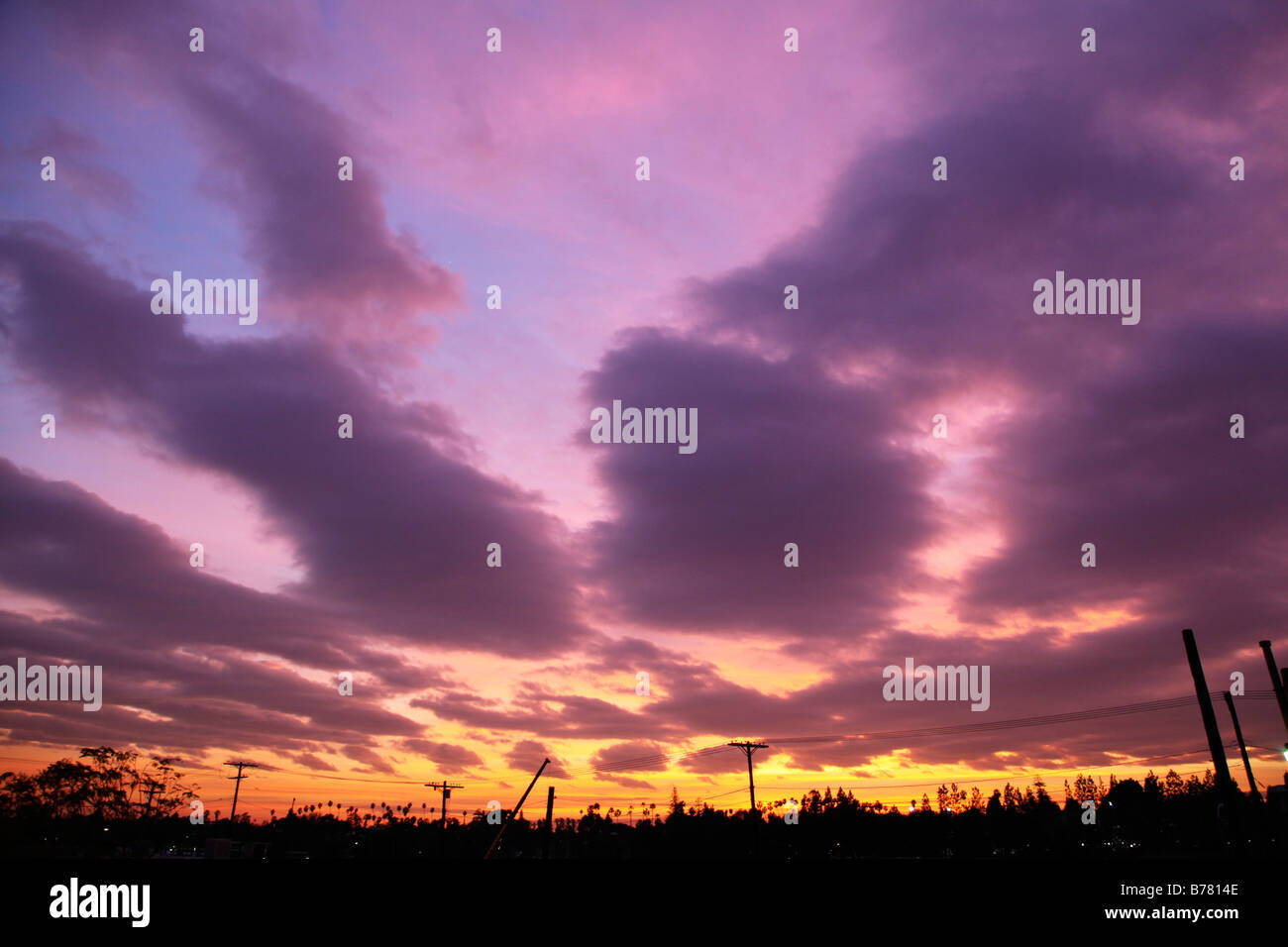Sonnenuntergang lila Wolken Telefonmasten Silhouette big Sky dramatischer Himmel Wetter Stockfoto