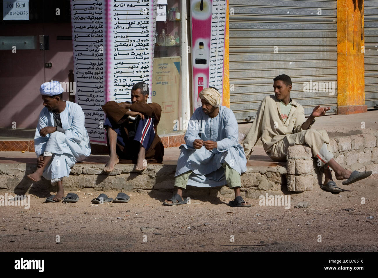 eine Gruppe von Einheimischen sitzen auf den Bordstein in Dahab Ägypten Stockfoto