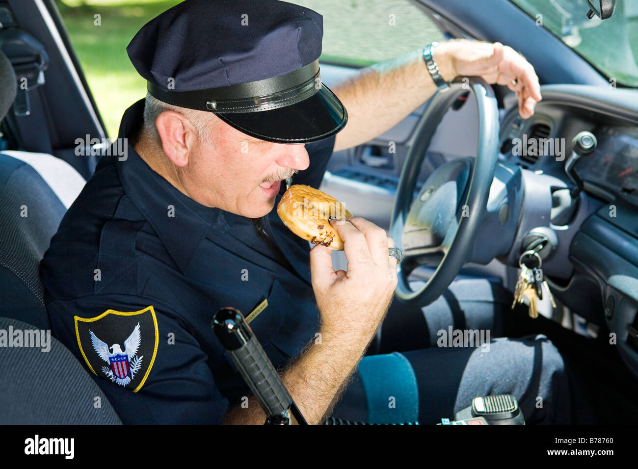Polizist in seinem Streifenwagen, ein bisschen von einem donut Stockfoto