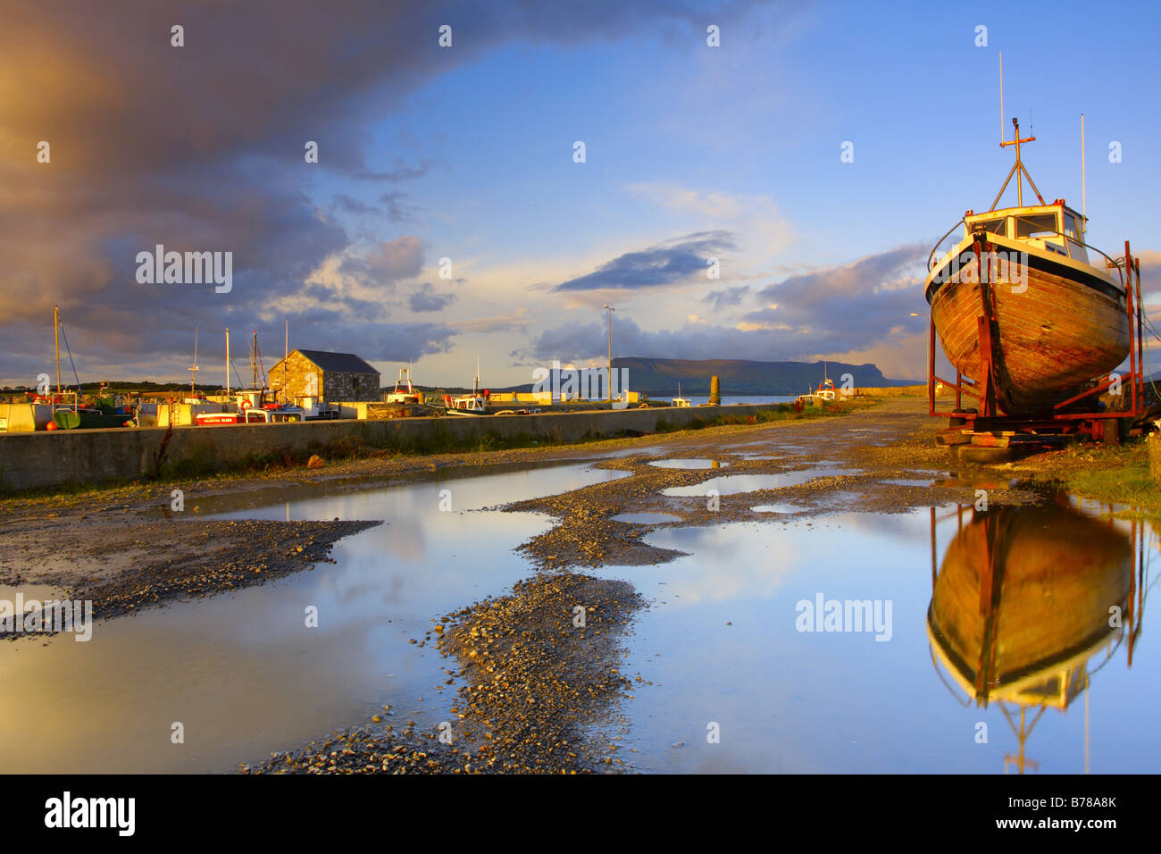 Boot, spiegelt sich auf dem Wasserteich im Raughly Hafen, Co. Sligo, Irland Stockfoto