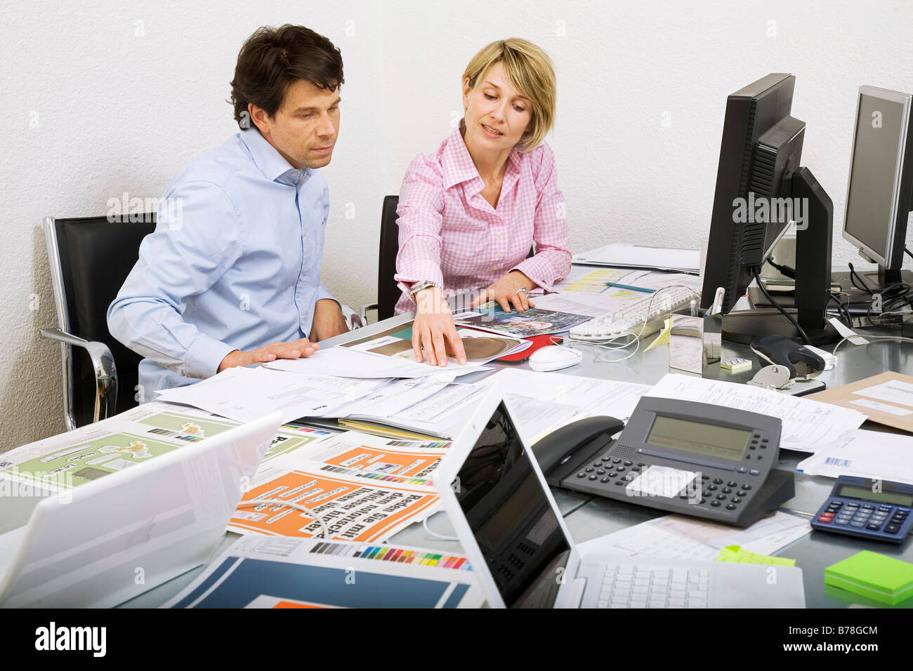 Mitarbeiter einer Werbeagentur, die Diskussion über eine Ad-Broschüre und Baupläne von einer Anzeige Kampagne, Zürich, Schweiz, Europa Stockfoto