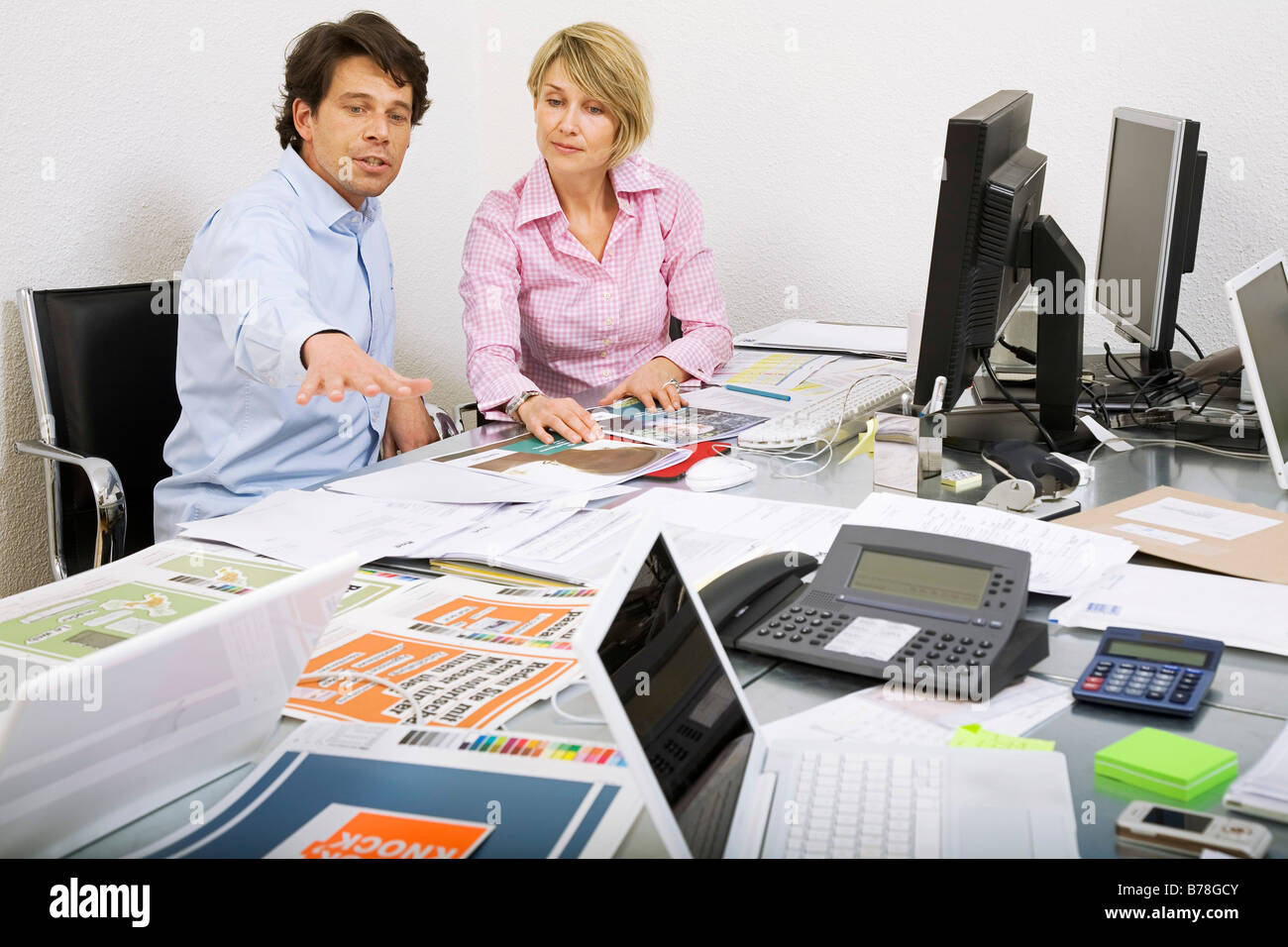 Mitarbeiter einer Werbeagentur, die Diskussion über eine Ad-Broschüre und Baupläne von einer Anzeige Kampagne, Zürich, Schweiz, Europa Stockfoto