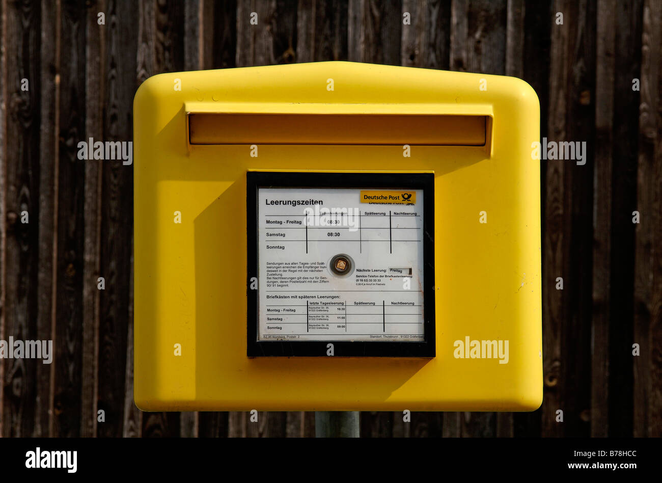 Gelber Briefkasten vor einer Scheune Geländer in Thuisbrunn, Upper Franconia, Bayern, Deutschland, Europa Stockfoto