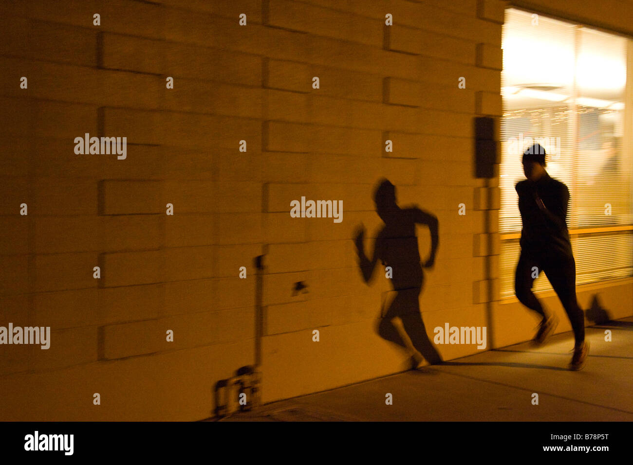 Ein Mann läuft entlang der Straße in der Nacht unter den Lichtern von Reno in Nevada Stockfoto