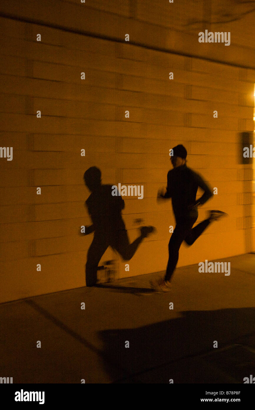 Ein Mann läuft entlang der Straße in der Nacht unter den Lichtern von Reno in Nevada Stockfoto