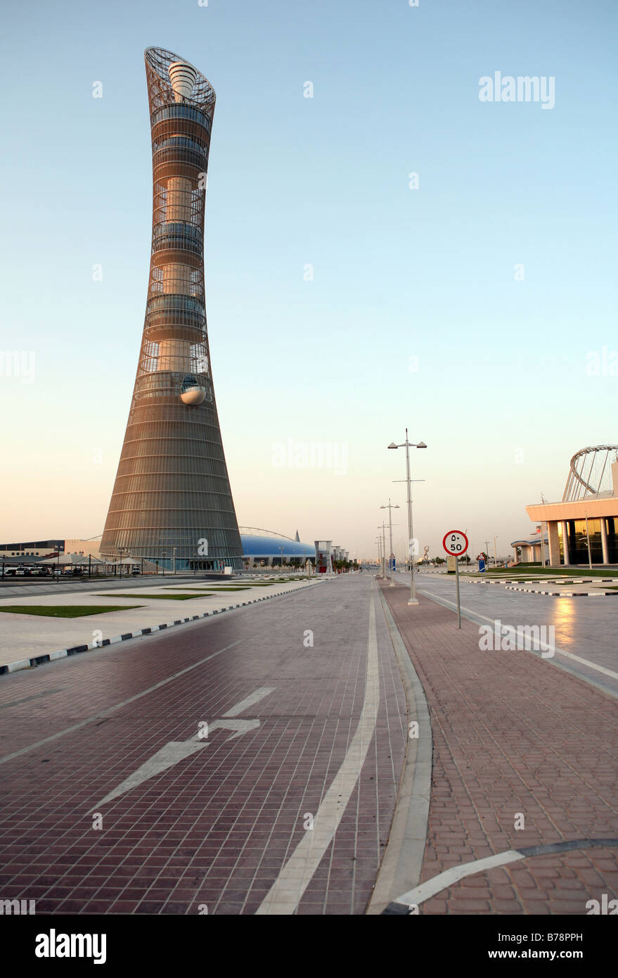 Die Straße, die aus Katar Aspire Sporttraining Komplex, vorbei an riesigen 2006 asiatische Spiele Fackel. Stockfoto