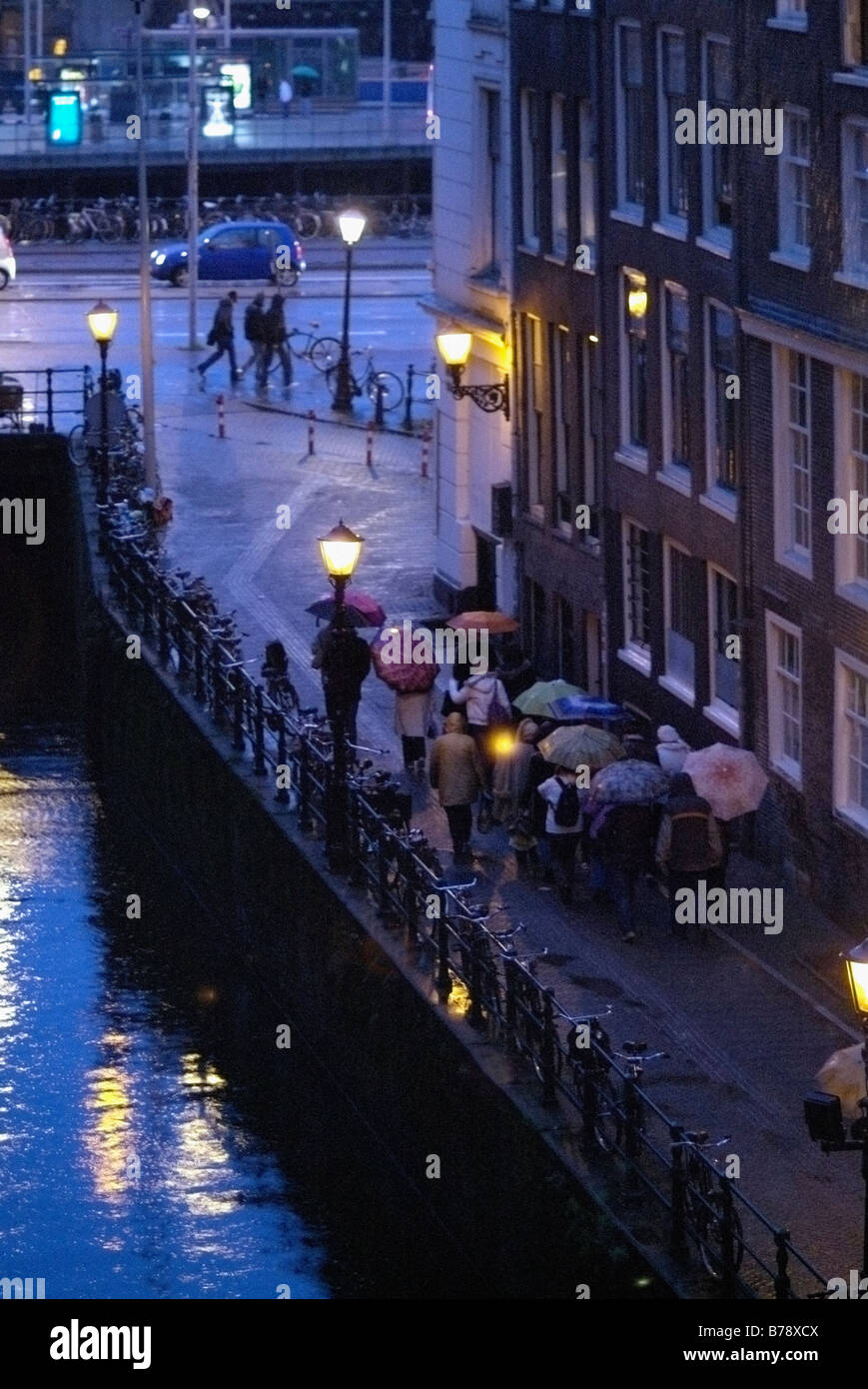 Gruppe von Touristen in Amsterdam an einem nassen Abend Stockfoto