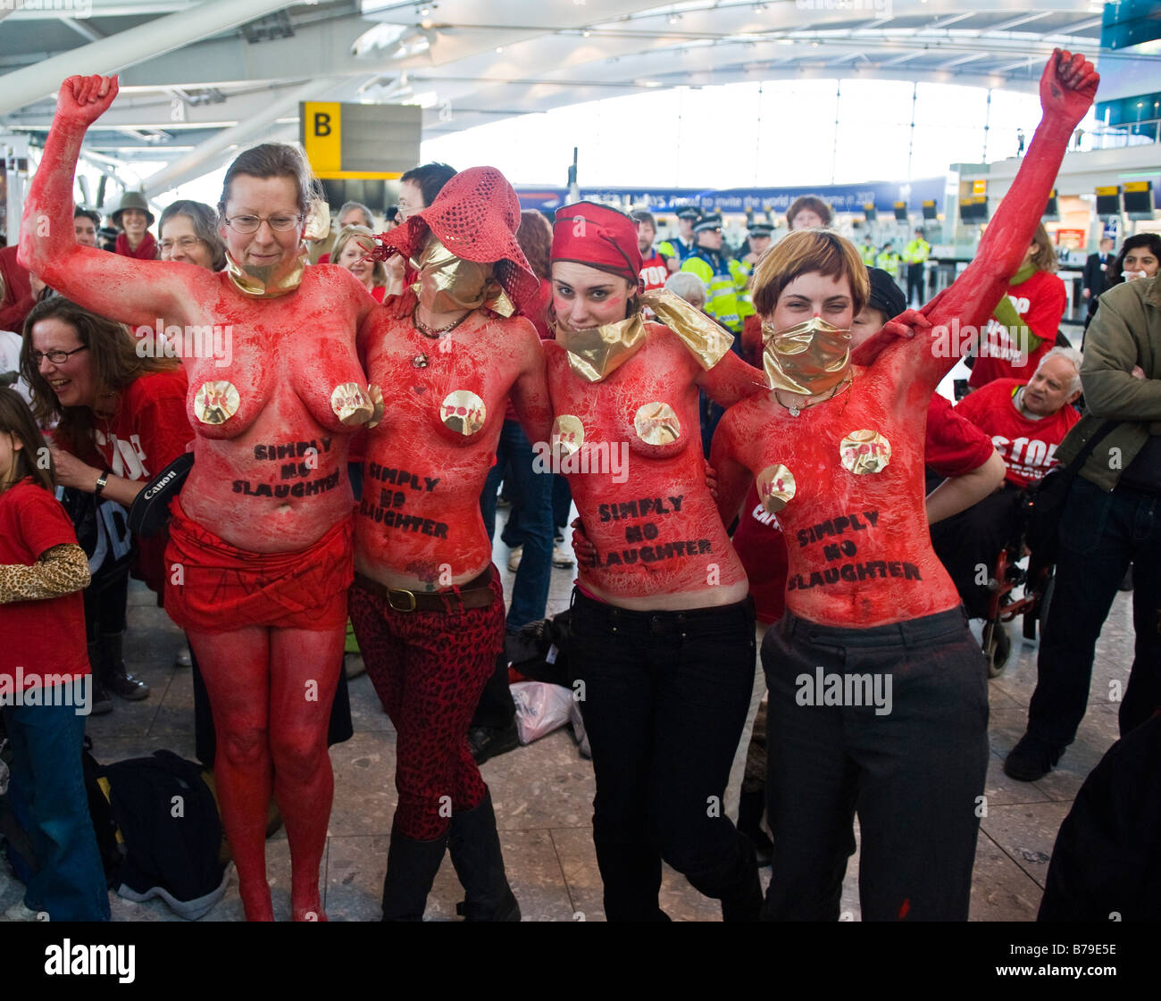 Eine Gruppe von weiblichen Aktivisten tragen rote Körperfarbe bei "Flashmob" Protest im Flughafen Heathrow Terminal 5 Stockfoto