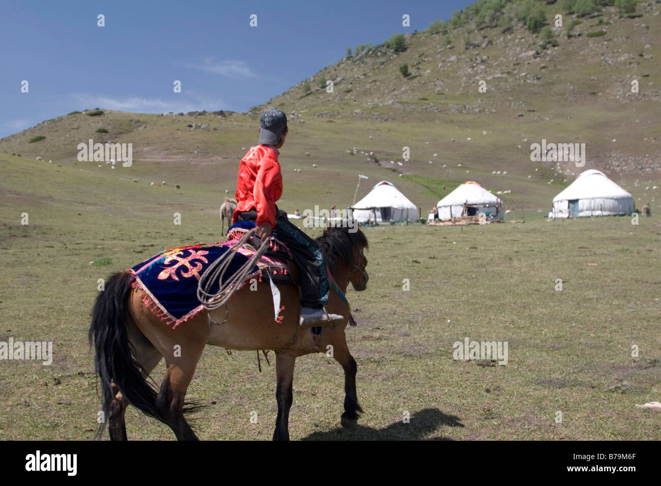 Ein Mongole reitet sein Pferd, seine Jurte Feldlager. Stockfoto