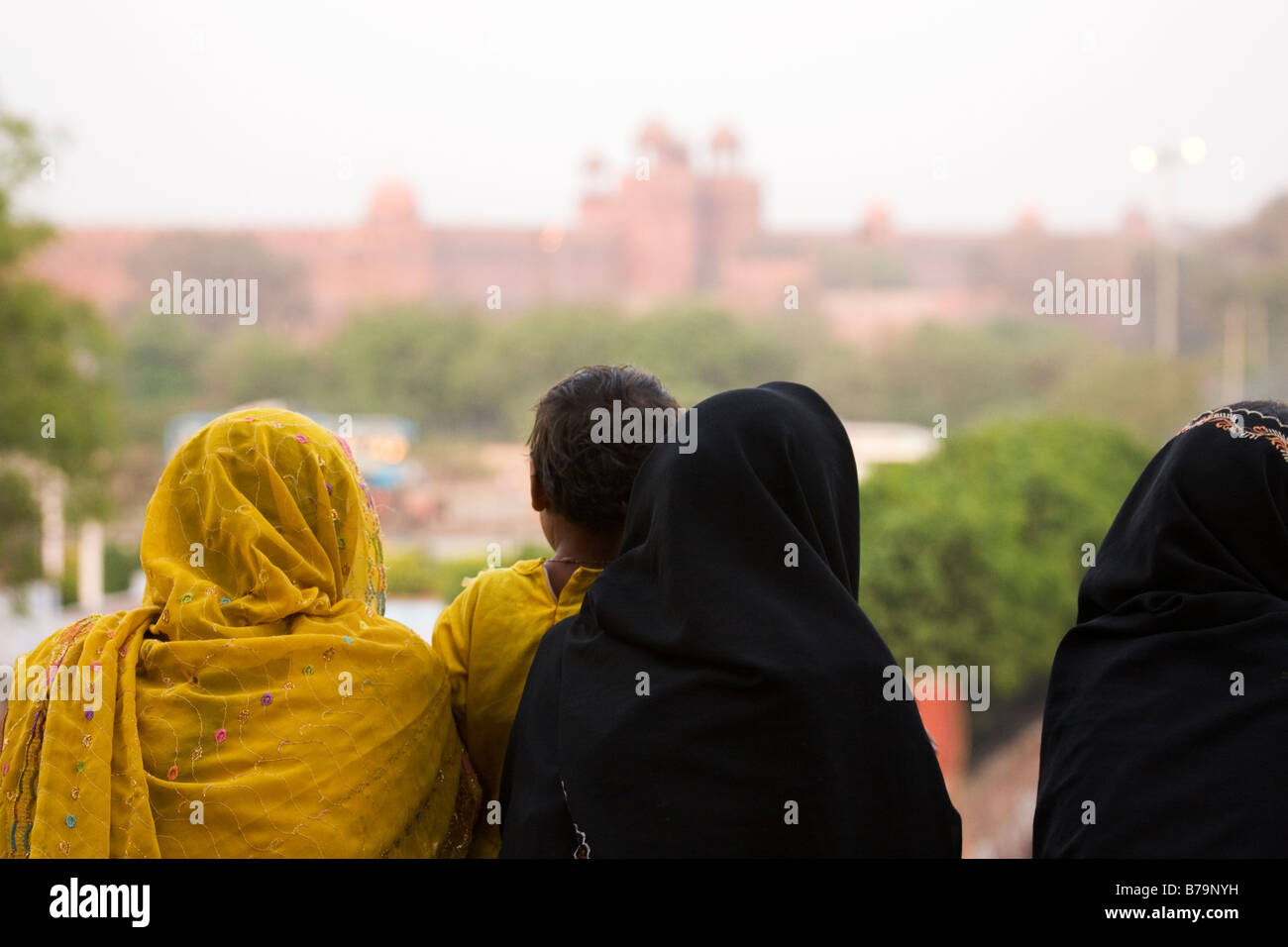 Muslimische Frauen sitzen auf den Stufen der Jama Masjid in Delhi, Indien. Sie blicken auf das Rote Fort. Stockfoto