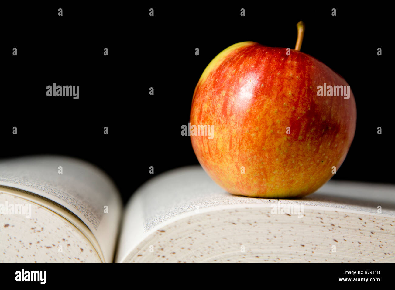 Apfel auf Buch Stockfoto