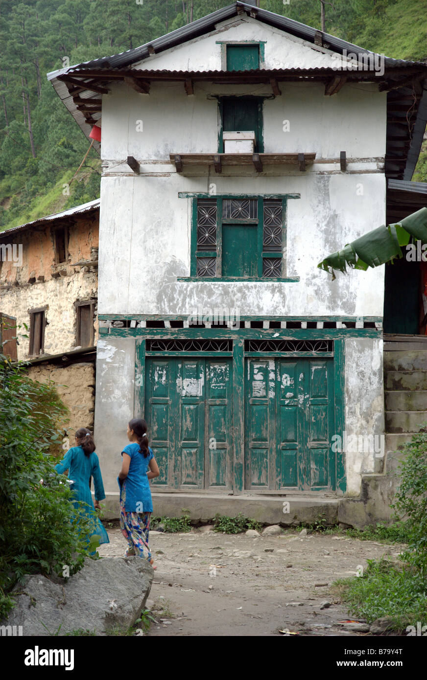 Zwei Mädchen gehen von einem Haus im Stadtteil Dorf Singati Bazar, Tamakoshi Tal, Dolakha, Nepal Stockfoto