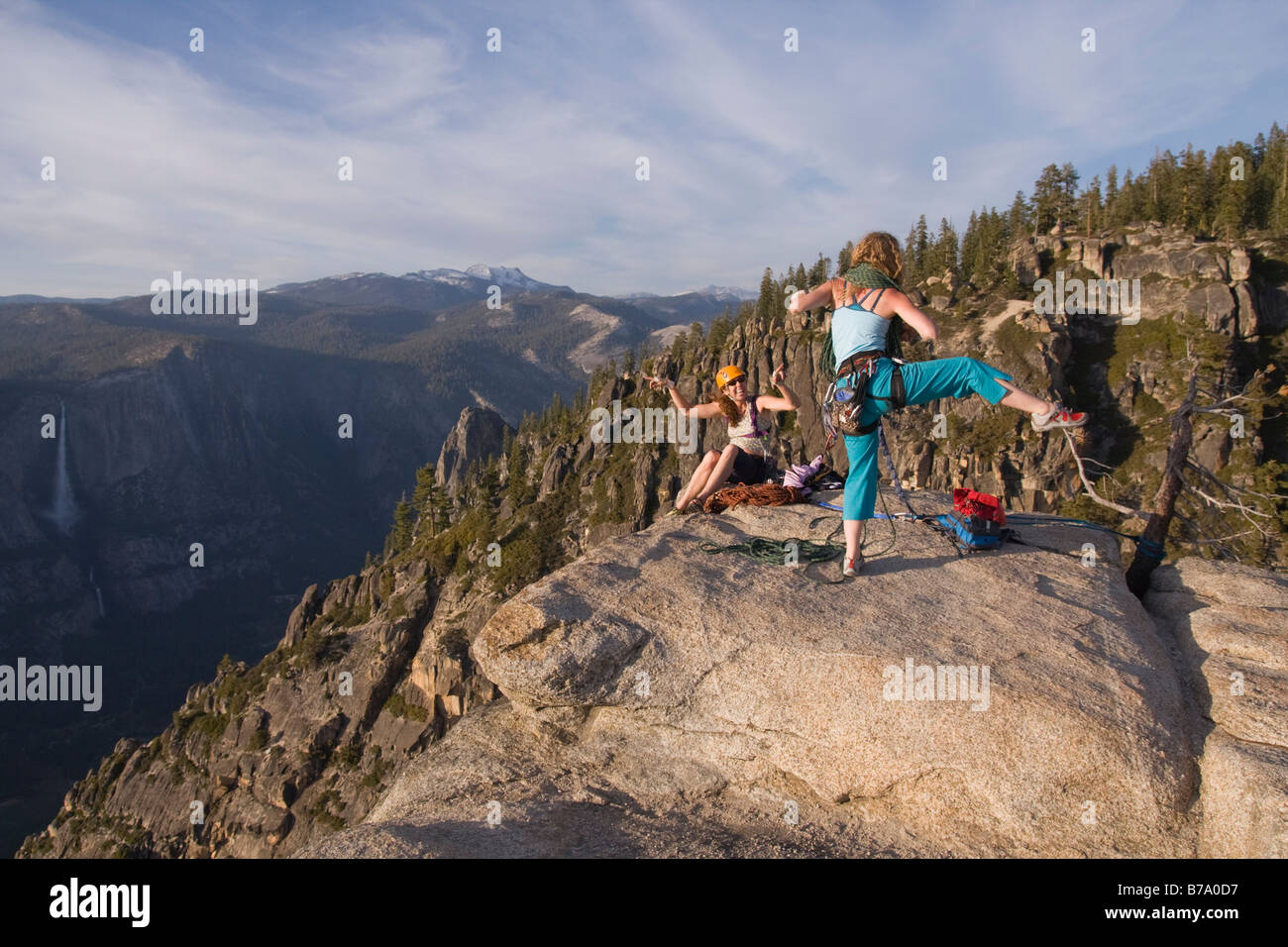 Zwei weibliche Kletterer in Taft Point bei Sonnenuntergang tanzen bei Sonnenuntergang im Yosemite-Nationalpark in Kalifornien. Stockfoto