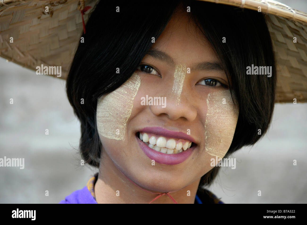 Lächelnde junge Frau trägt Tanaka auf ihr Gesicht und Reis Stroh Hut auf dem Kopf, Mingun, in der Nähe von Mandalay, Birma, Myanmar, Southea Stockfoto