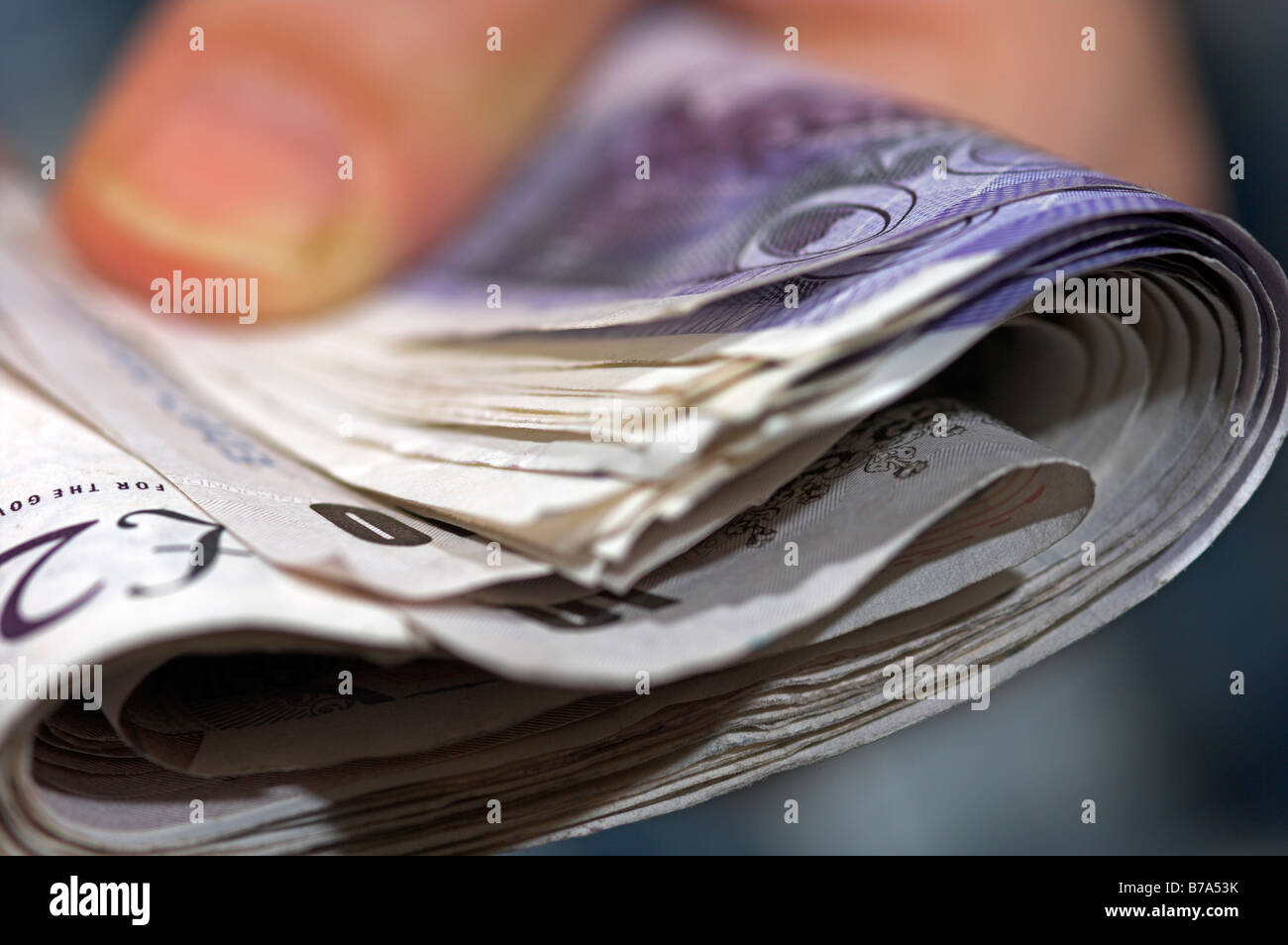 Hand hält ein Bündel von britischen Pfund Sterling Banknoten Stockfoto