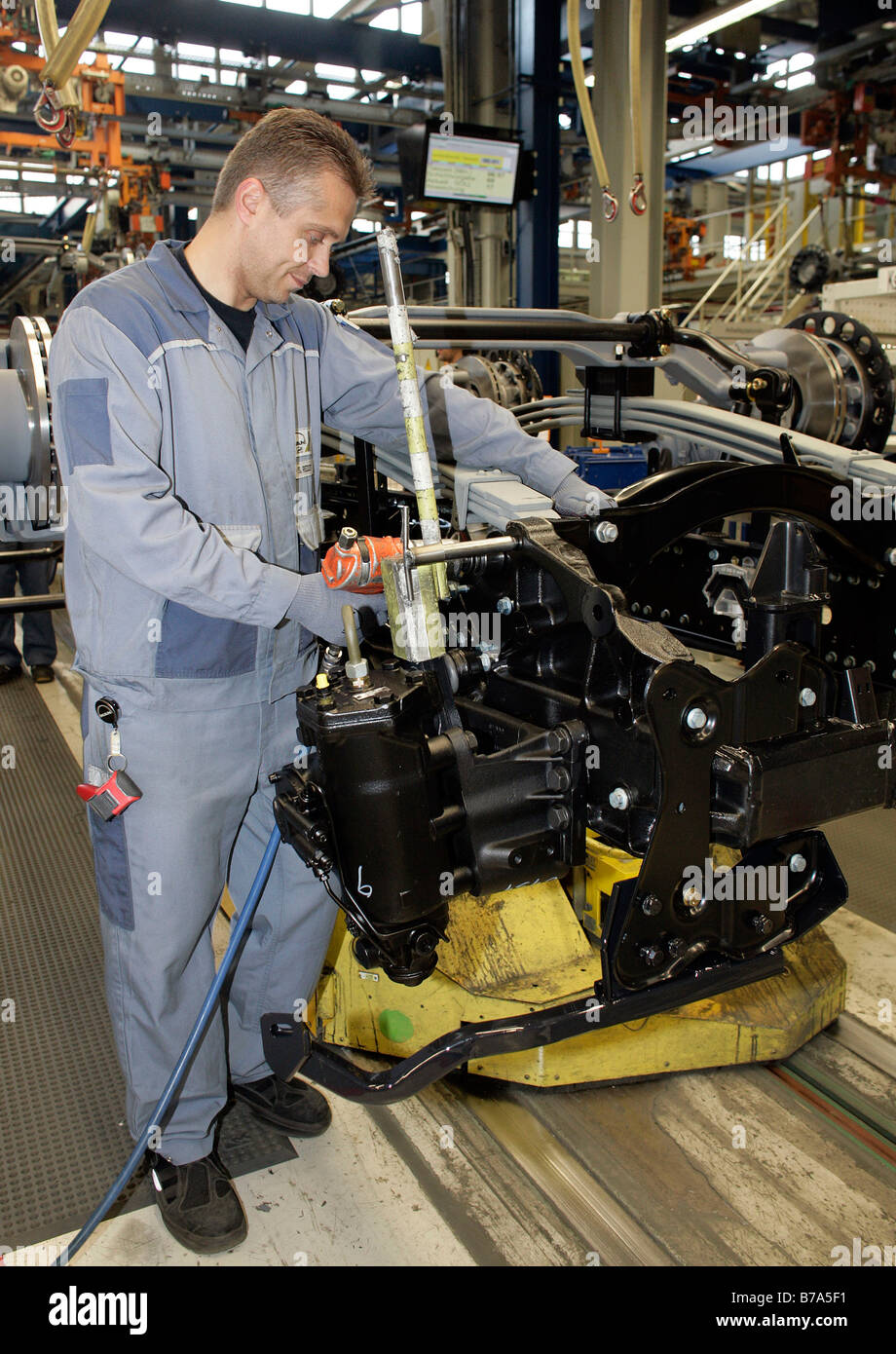 Arbeiter bei der Montage der Achse im Unterboden eines Lastwagens, Herstellung, Produktion Mann Nutzfahrzeug Corporation, München, Ba Stockfoto