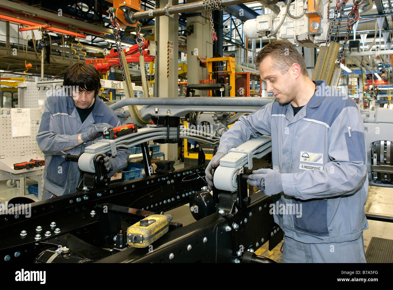 Arbeiter bei der Montage der Achse im Unterboden eines Lastwagens, Herstellung, Produktion Mann Nutzfahrzeug Corporation, München, Ba Stockfoto